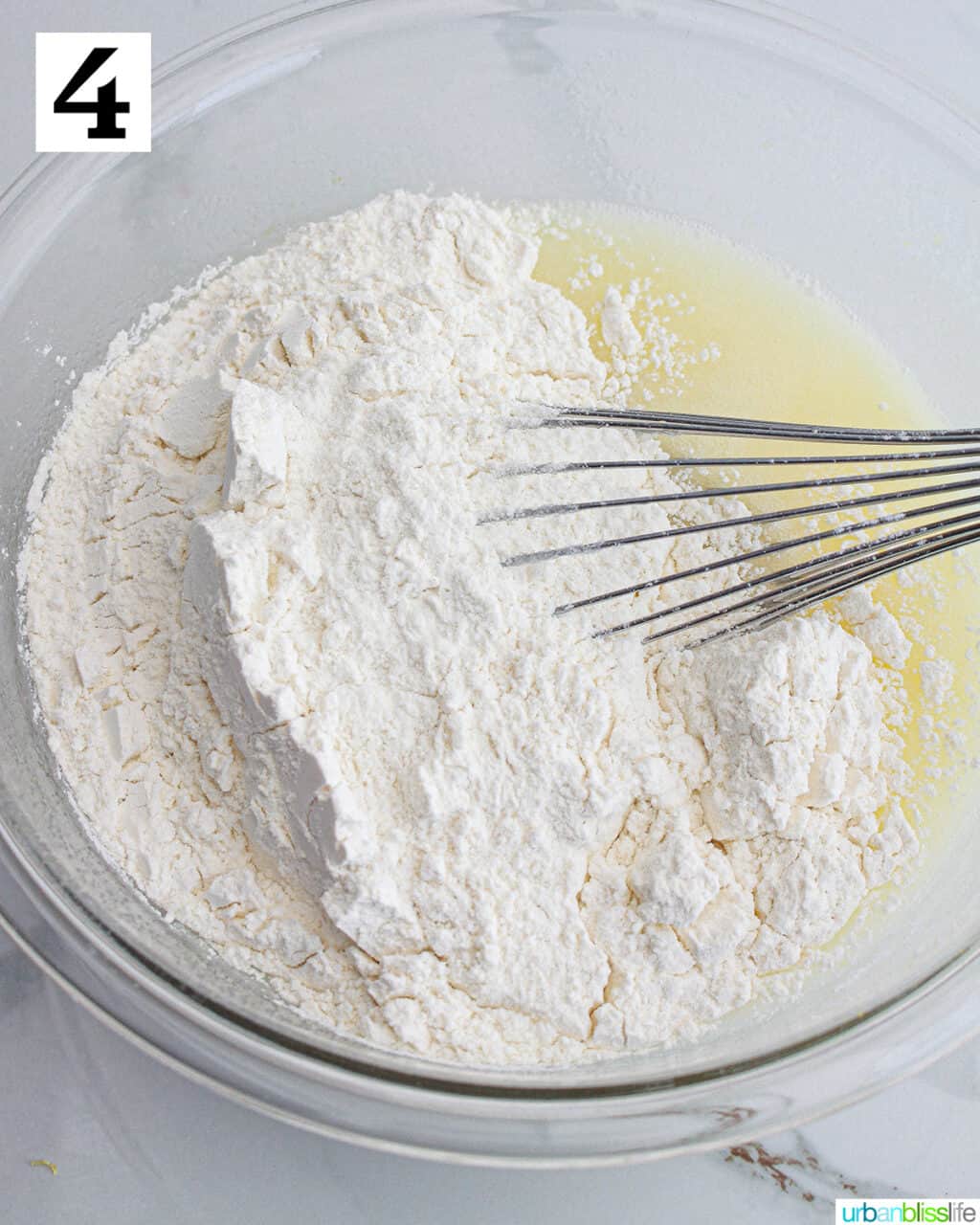 whisking dry ingredients into wet ingredients in a large bowl.