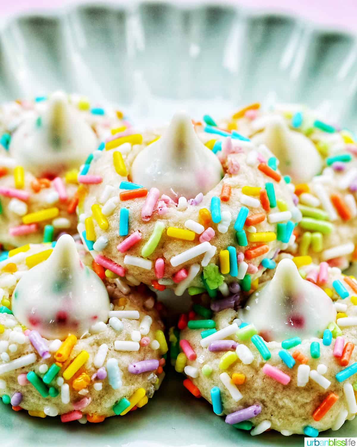 several spring almond sprinkle cookies stacked on top of one another.