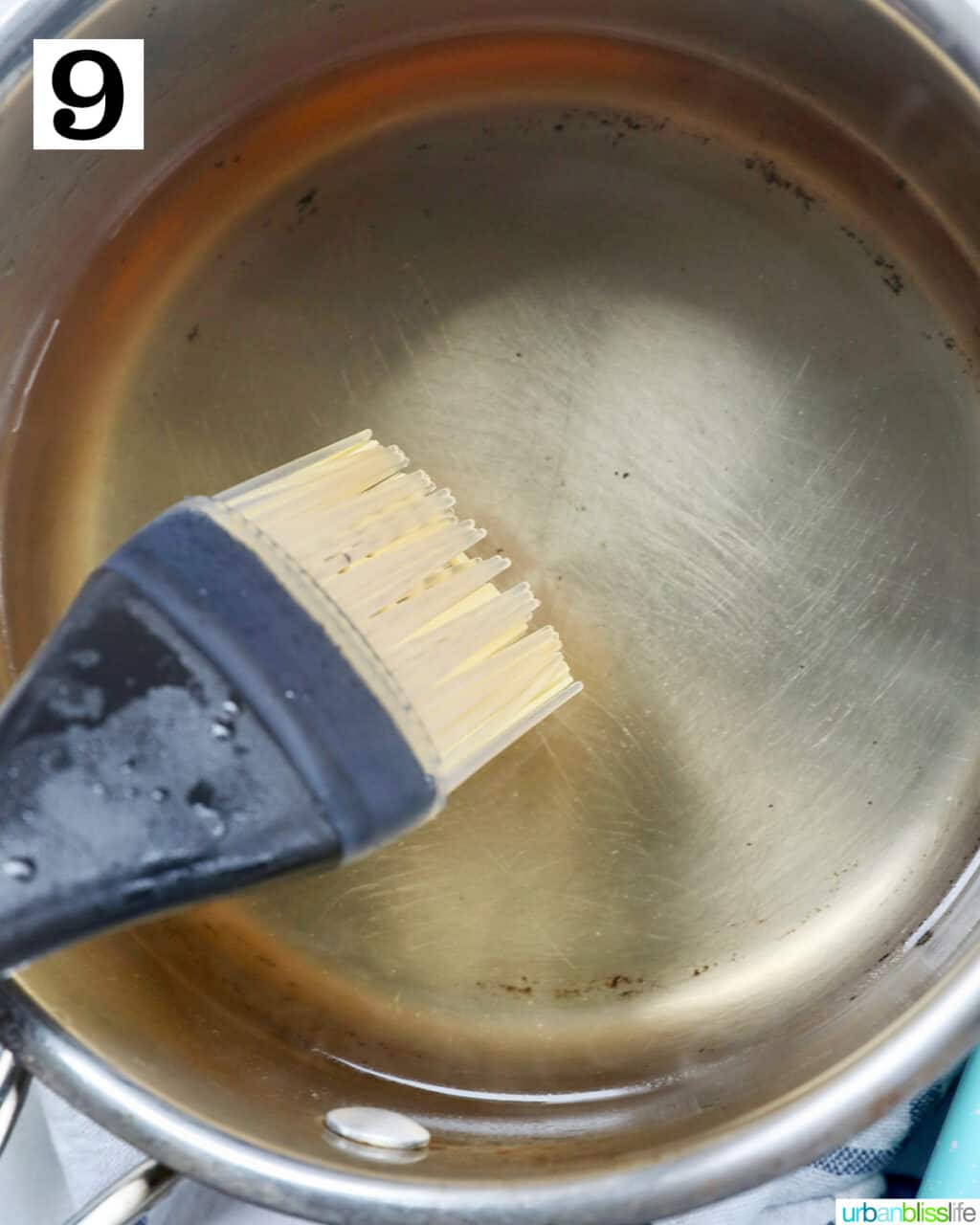 pastry brush in almond syrup in a pot.