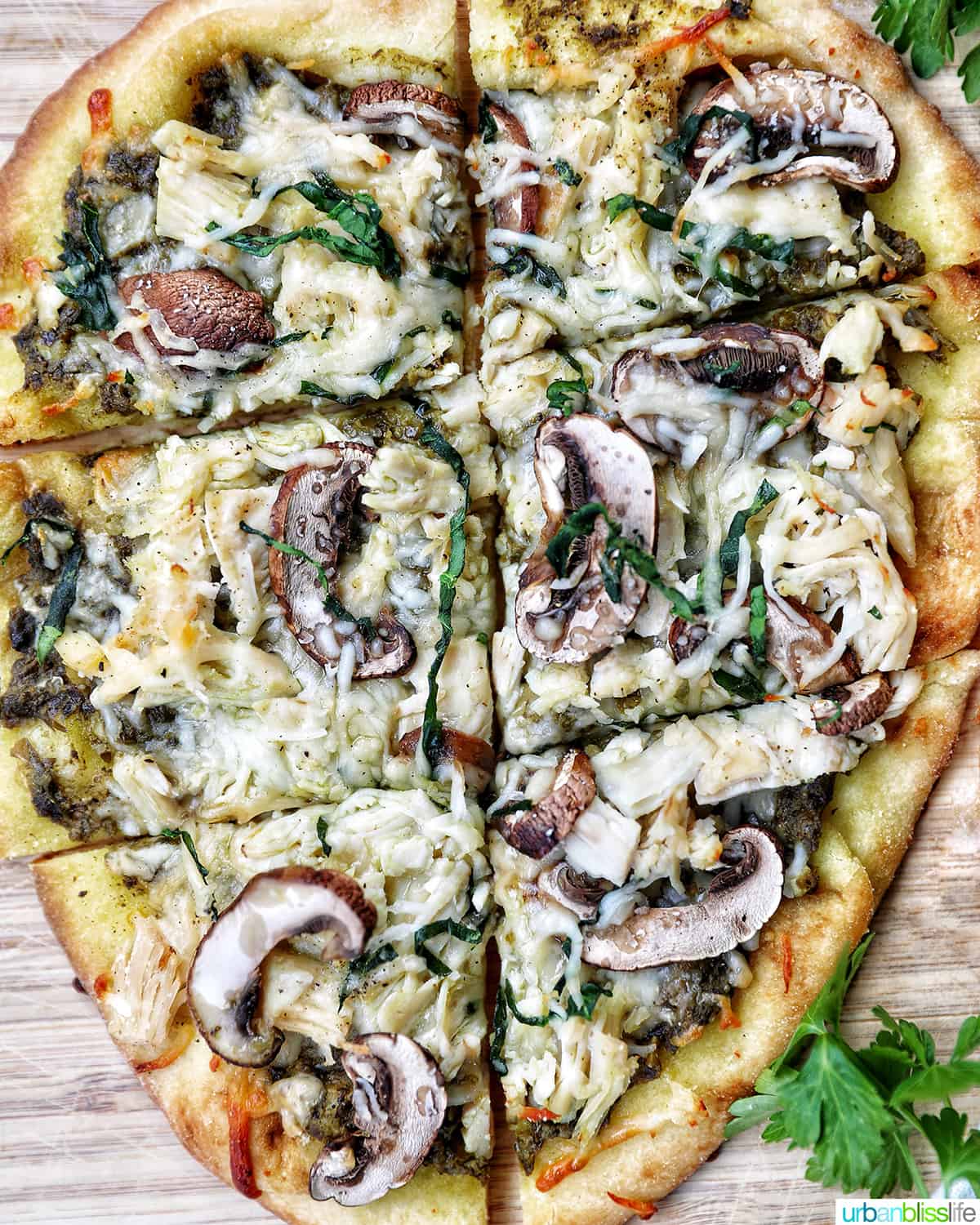 chicken pesto flatbread with mushrooms on a wooden board.
