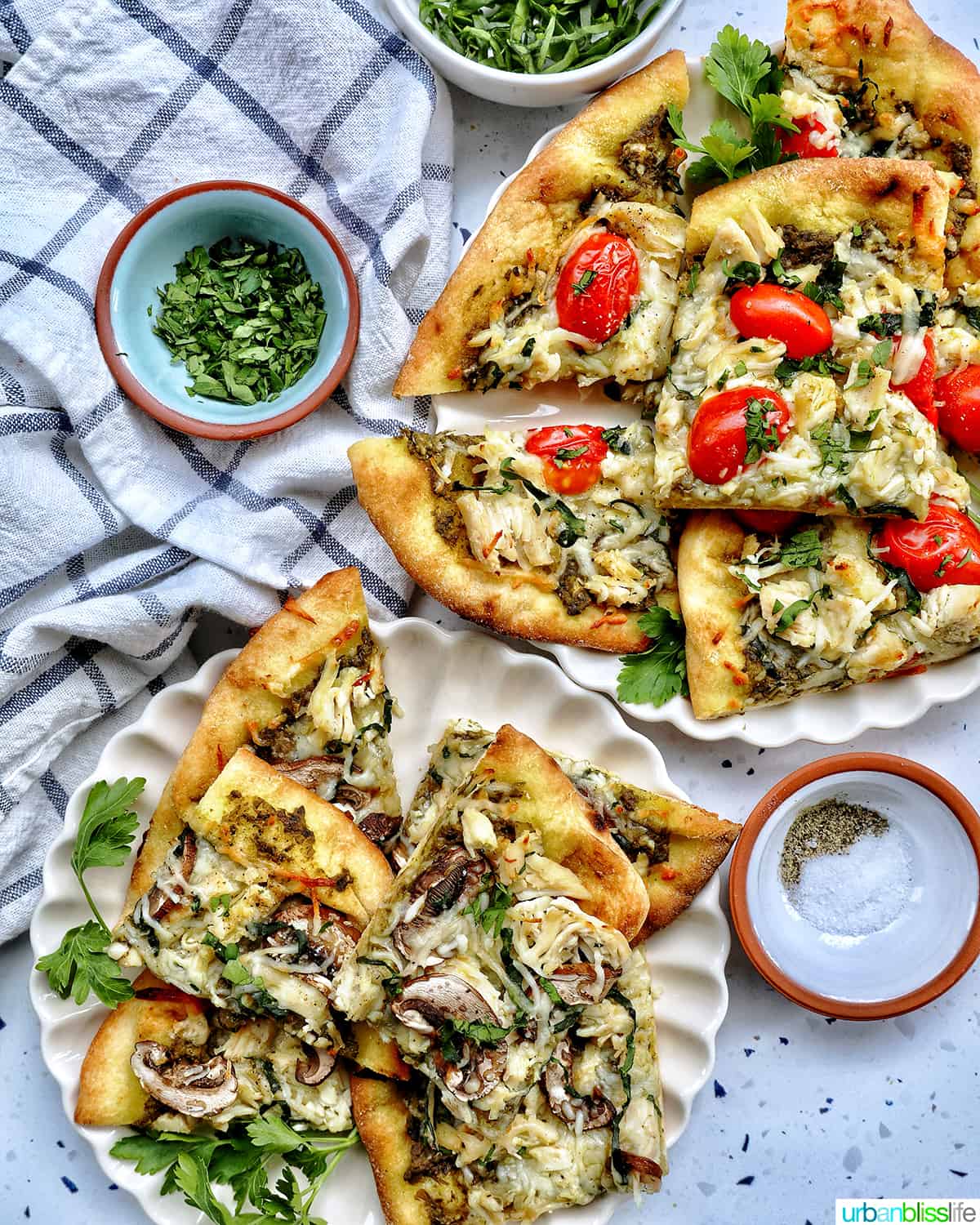 two chicken pesto flatbreads, one with tomatoes and one with mushrooms.