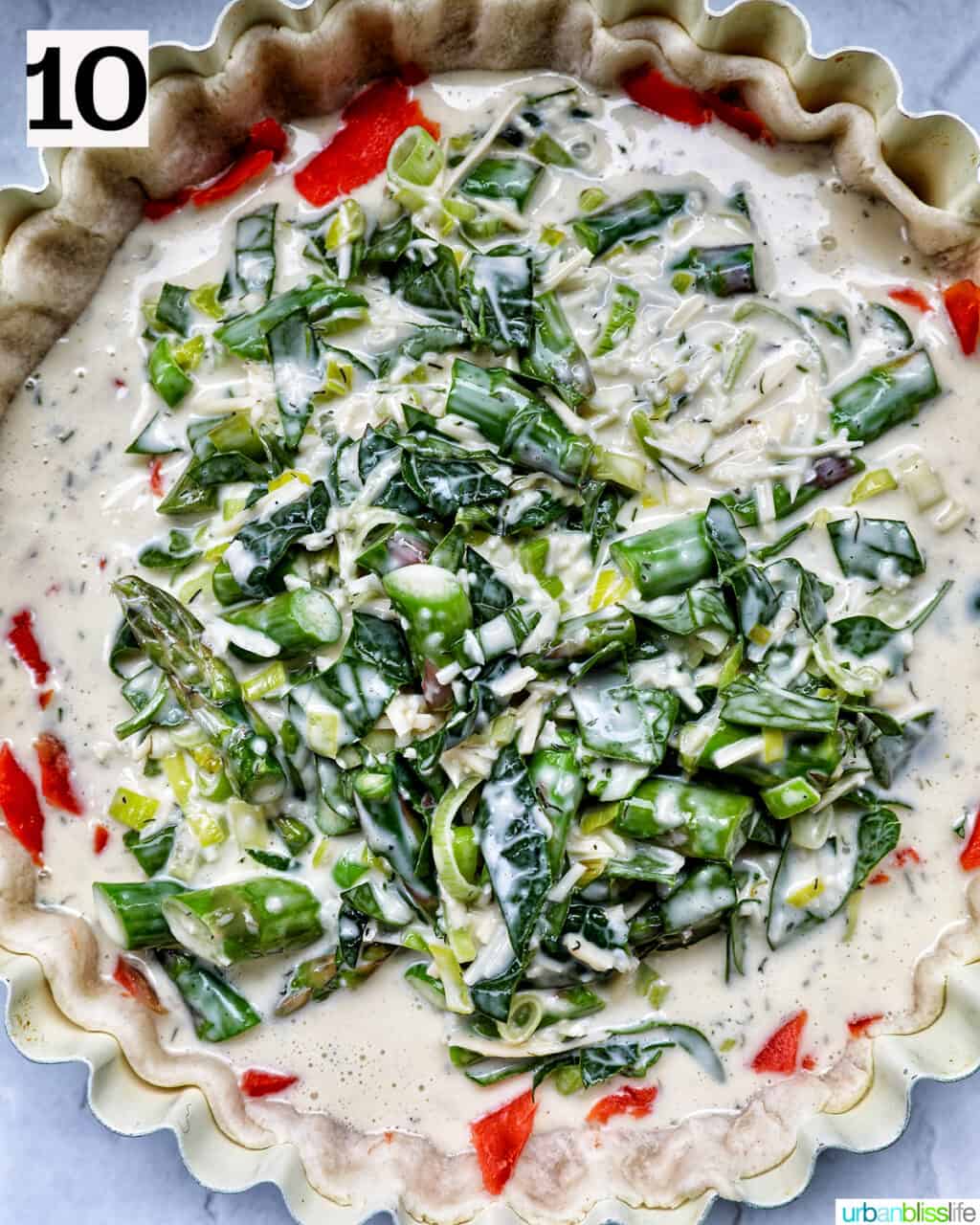 quiche filling with smoked salmon, asparagus, and leeks in a pie plate ready to bake.