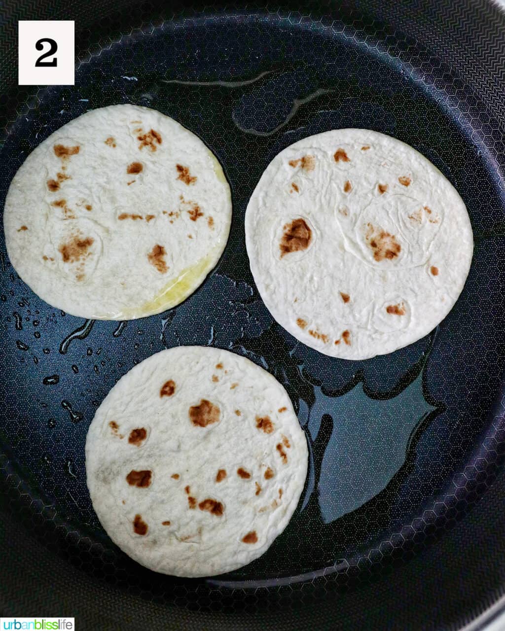 three tortillas in a pan.