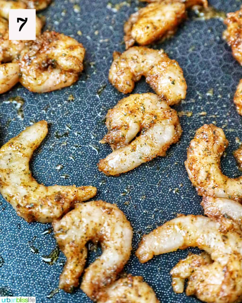 seasoned shrimp cooking on a pan.