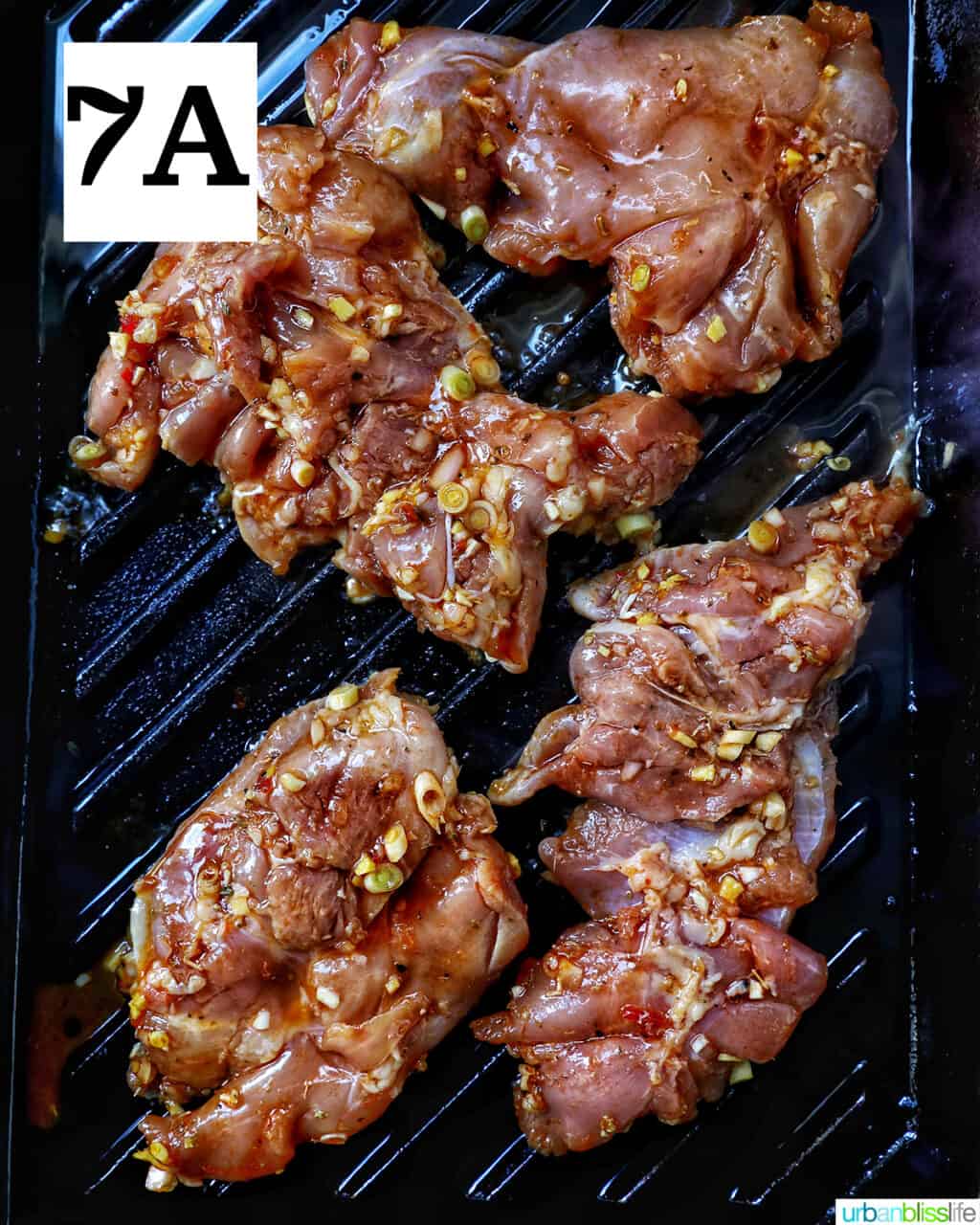 chicken thighs cooking on a grill pan.