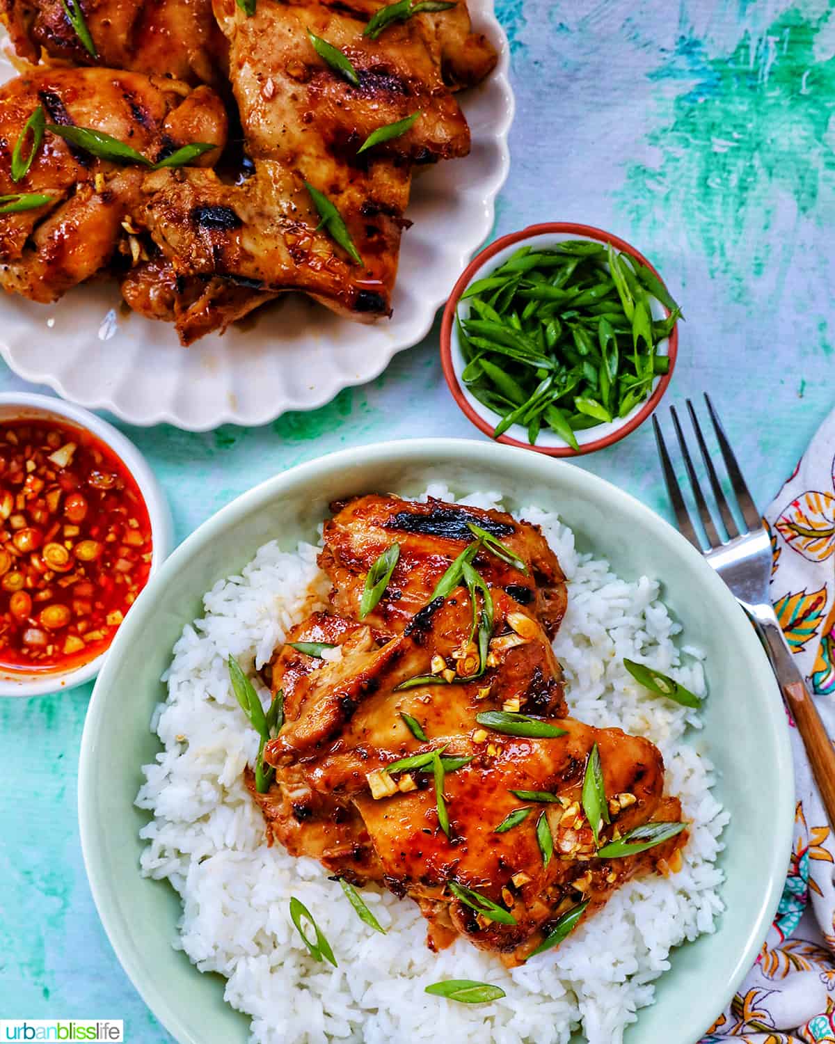 Plate with a stack of Thai Lemongrass Chicken over rice and sliced green onion garnish.
