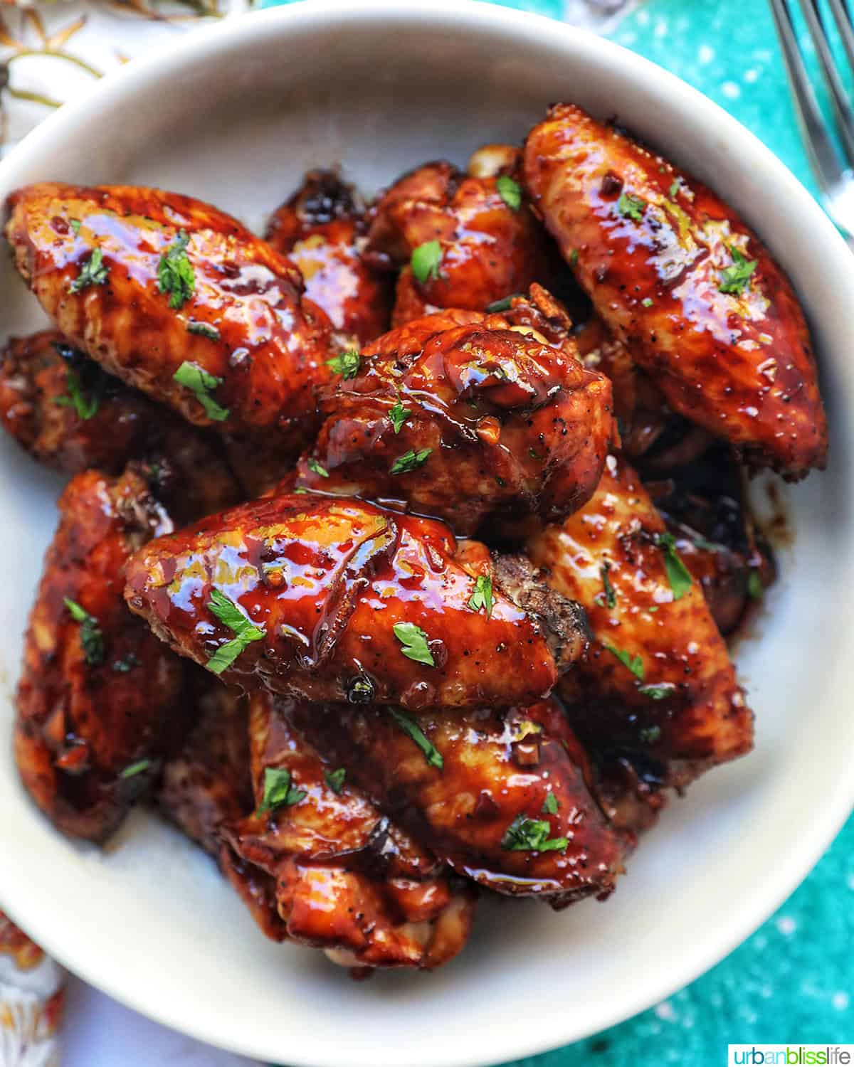 bowl of Filipino adobo chicken wings and fresh parsley.