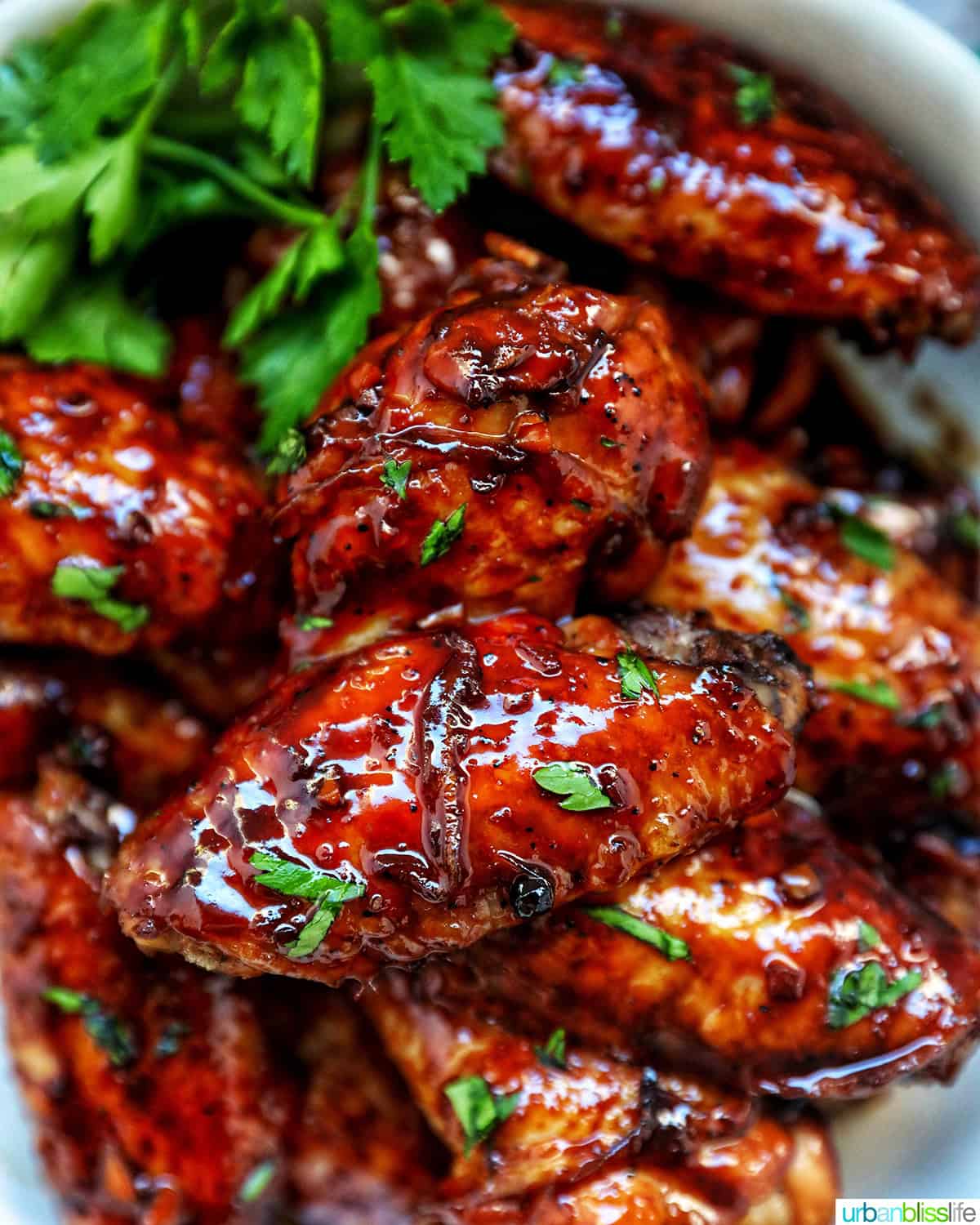 bowl of Filipino adobo chicken wings and fresh parsley.