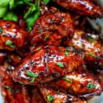 bowl of Filipino adobo chicken wings and fresh parsley.