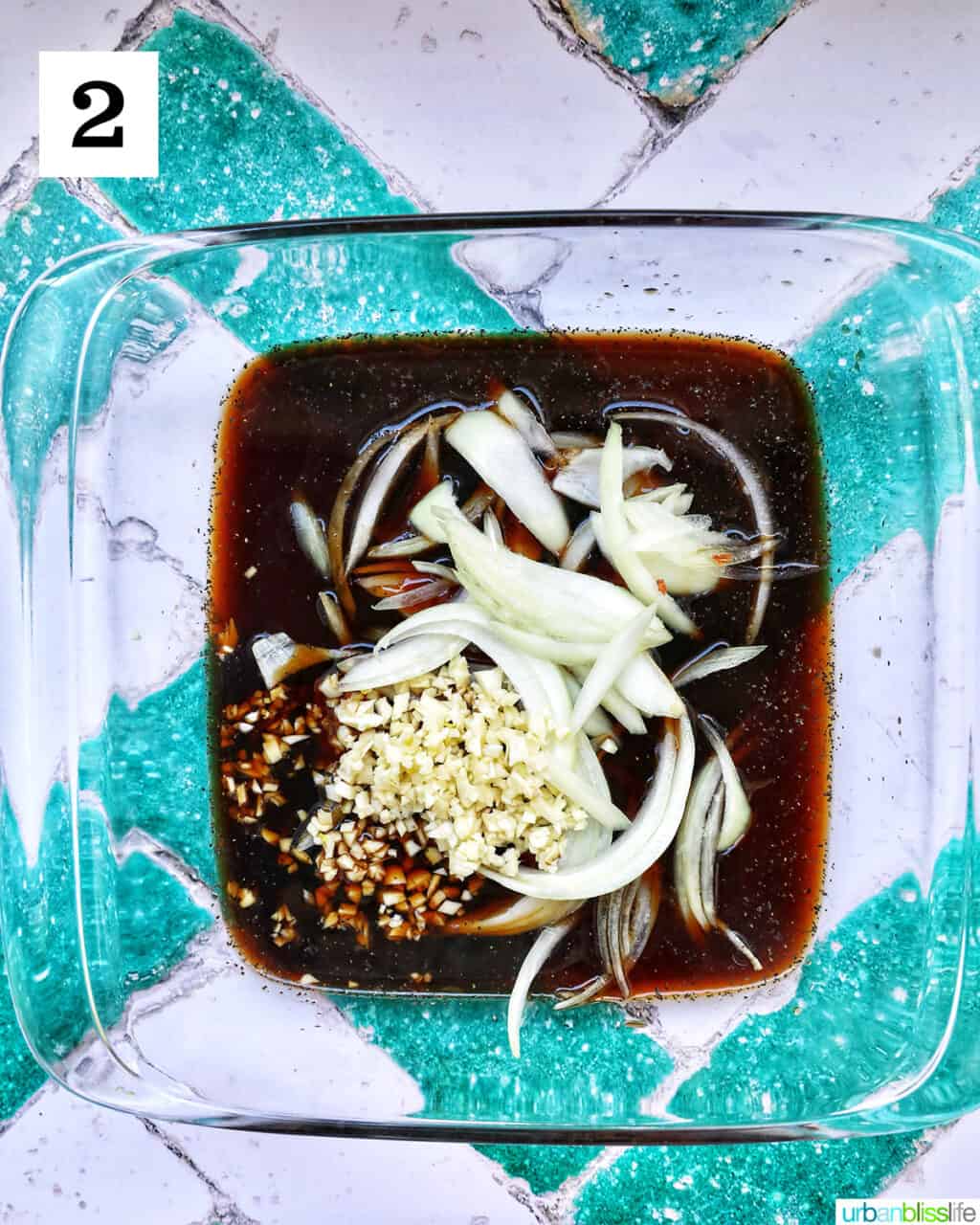 garlic, onions, and adobo sauce in a glass dish.