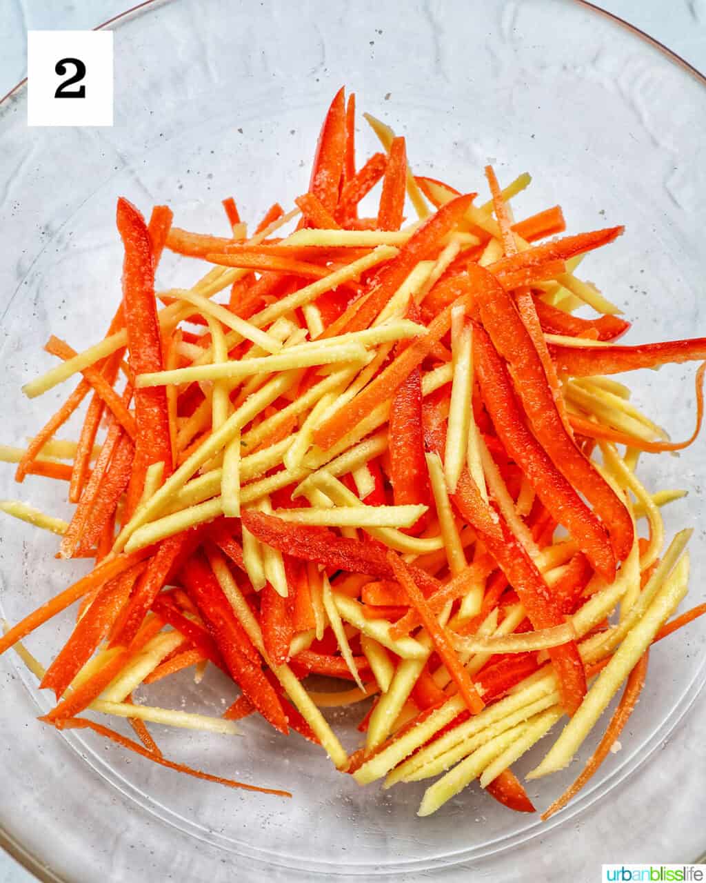 sliced papaya, carrots, red bell pepper in a bowl.