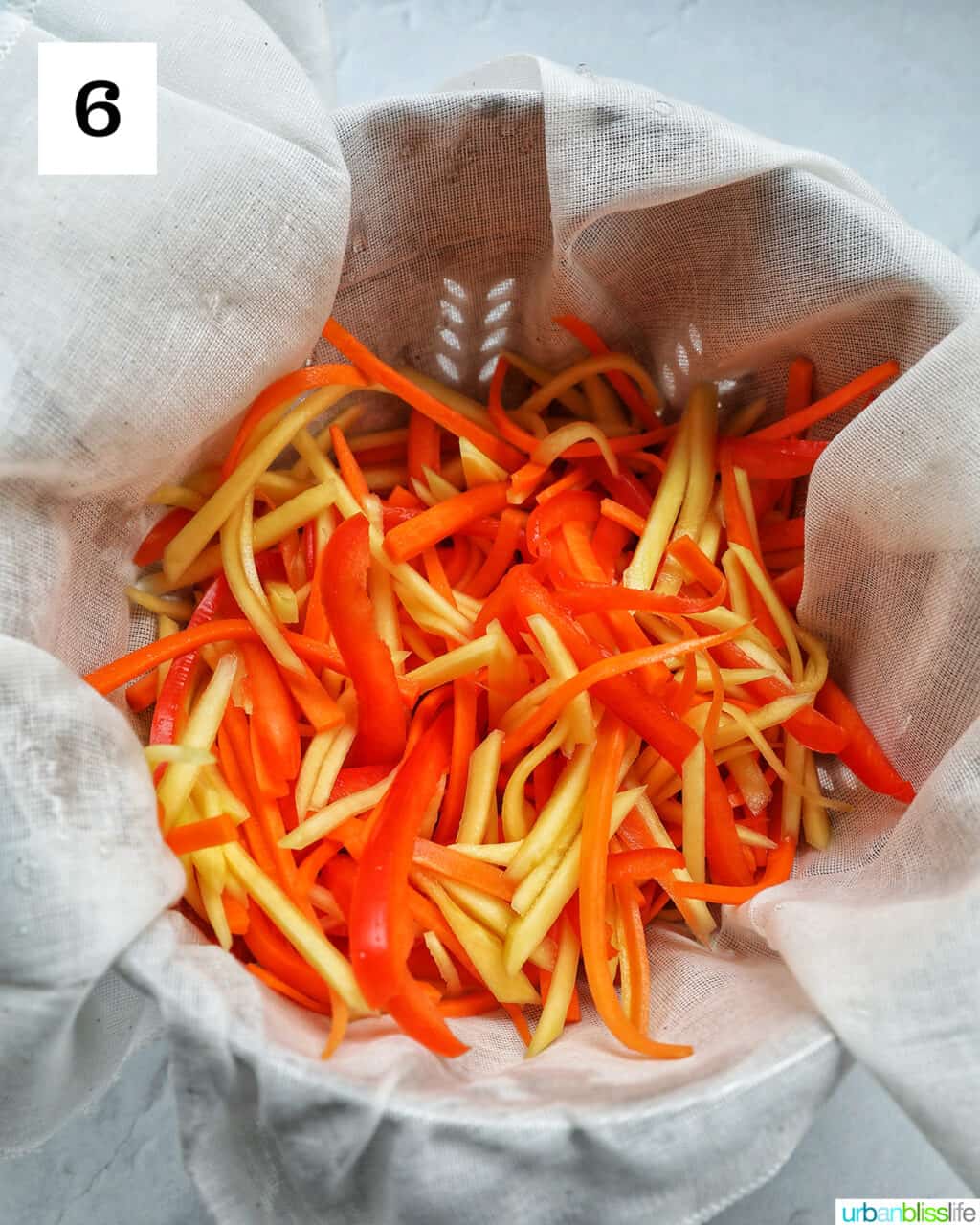 sliced papaya, carrots, red bell pepper in a bowl.