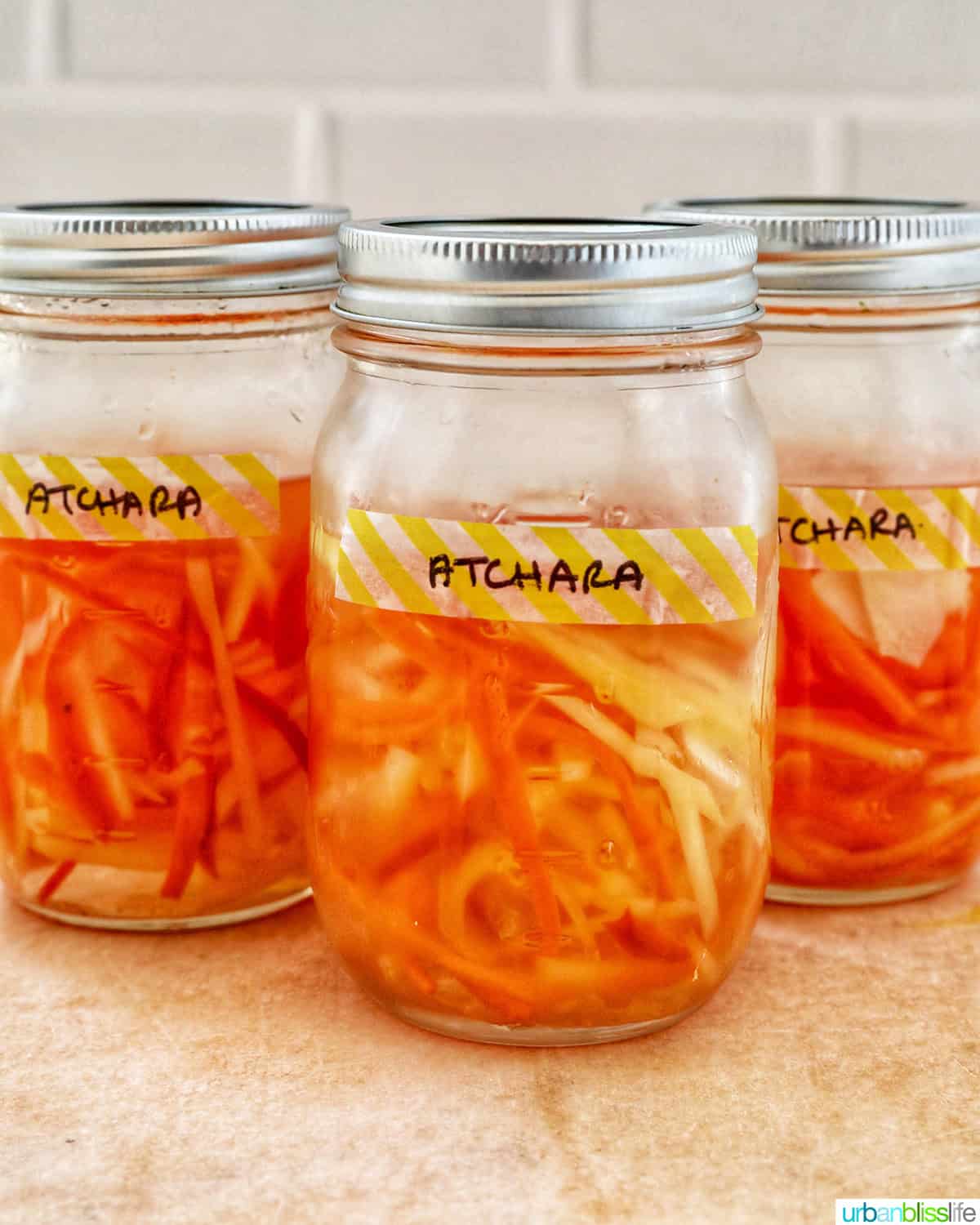 mason jars with Filipino atchara condiment - papaya, carrots, red bell pepper, garlic, ginger.