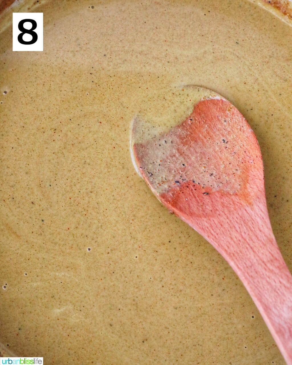 curry sauce with wooden spoon in a large pan.