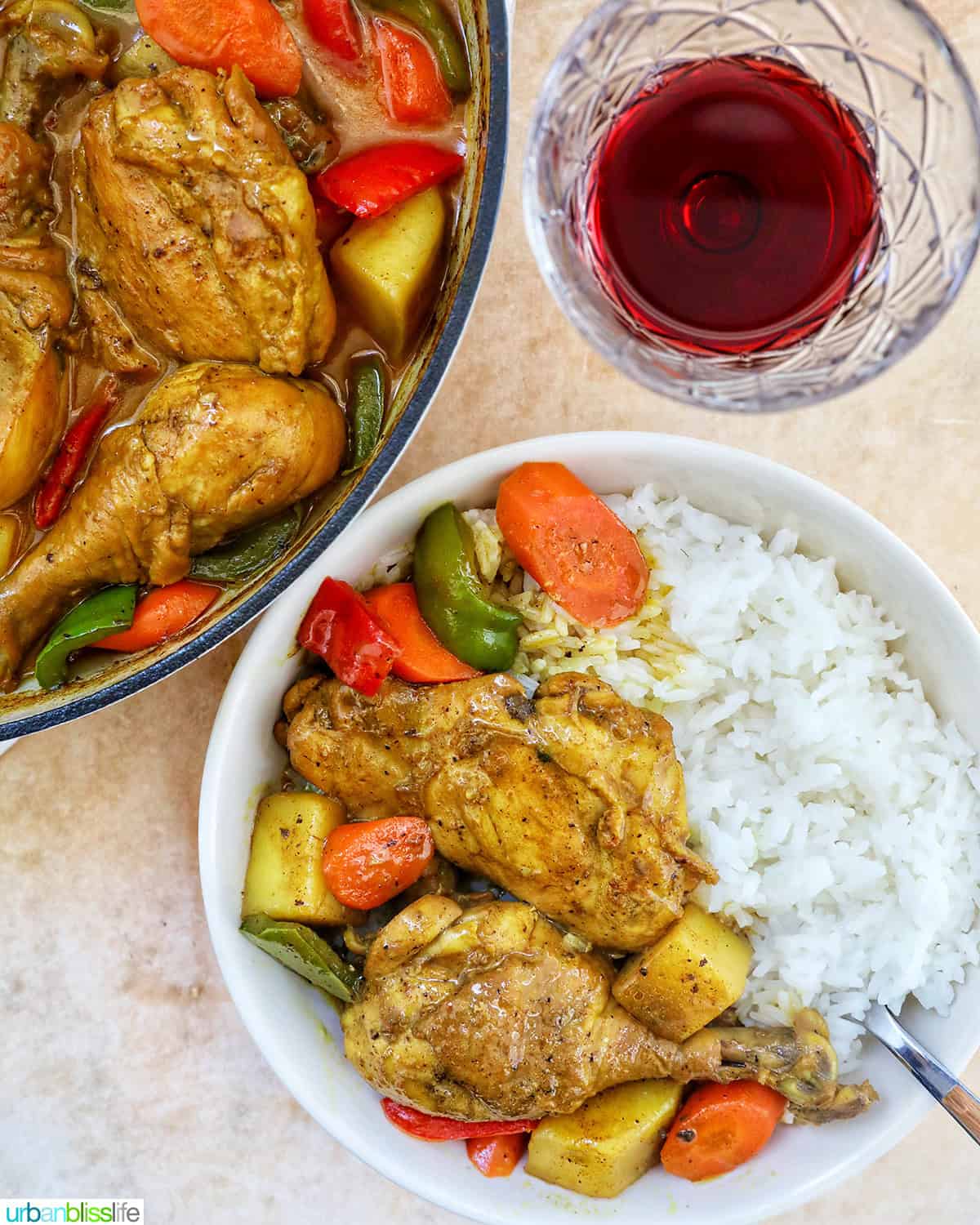 Filipino Chicken Curry with vegetables and white rice and glass of red wine.