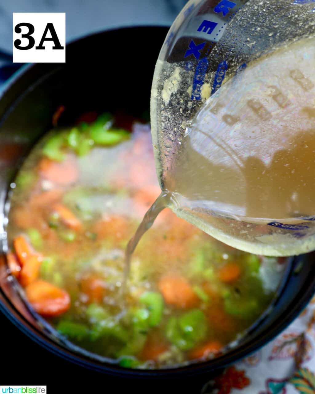 measuring cup of chicken stock adding liquid to a pot of soup.