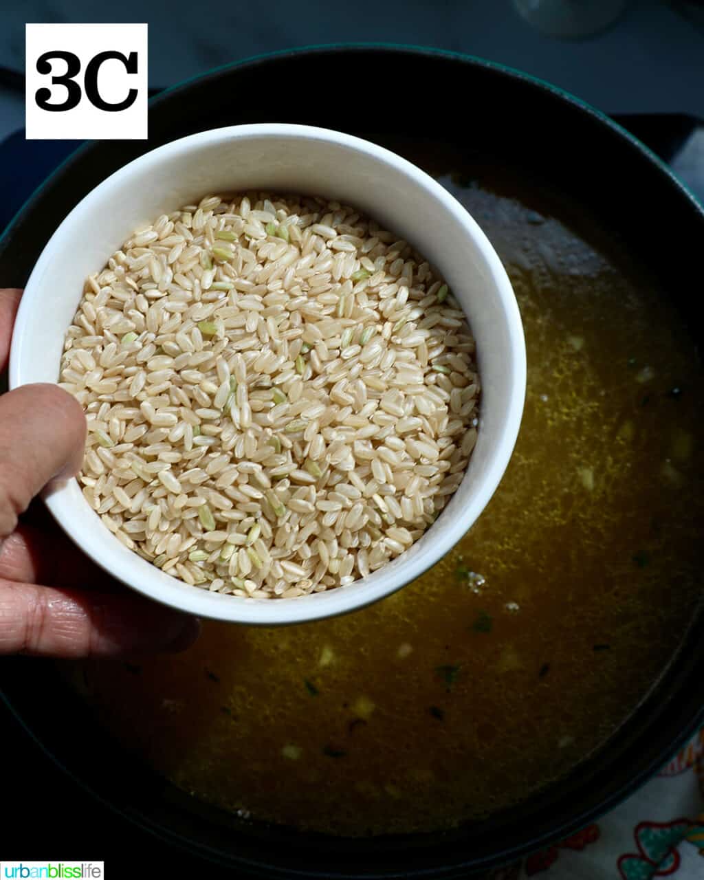 brown rice in a white bowl over a pot of soup.