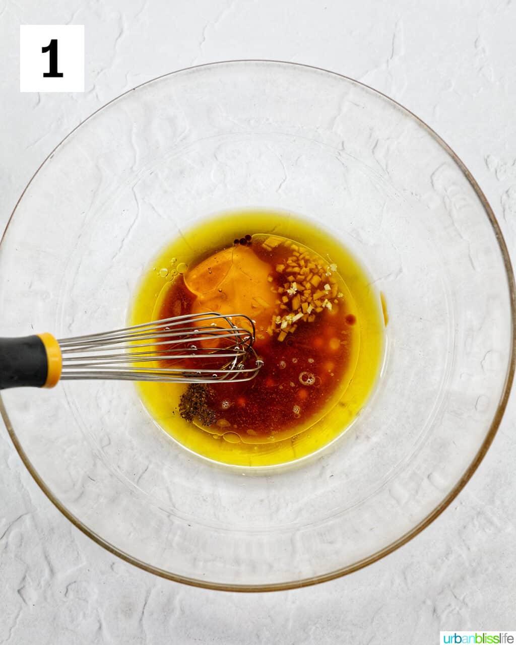 bowl of ingredients and a whisk for Asian dressing for mango slaw.