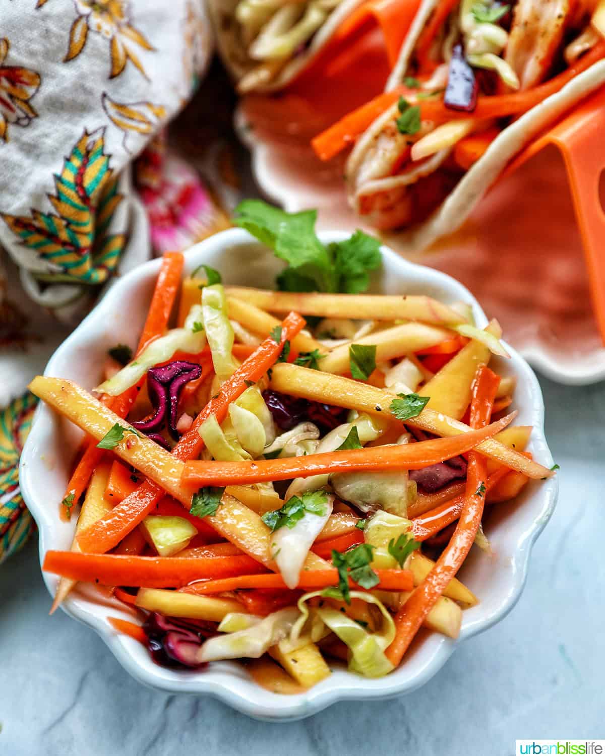 bowl of mango slaw with side of shrimp tacos.