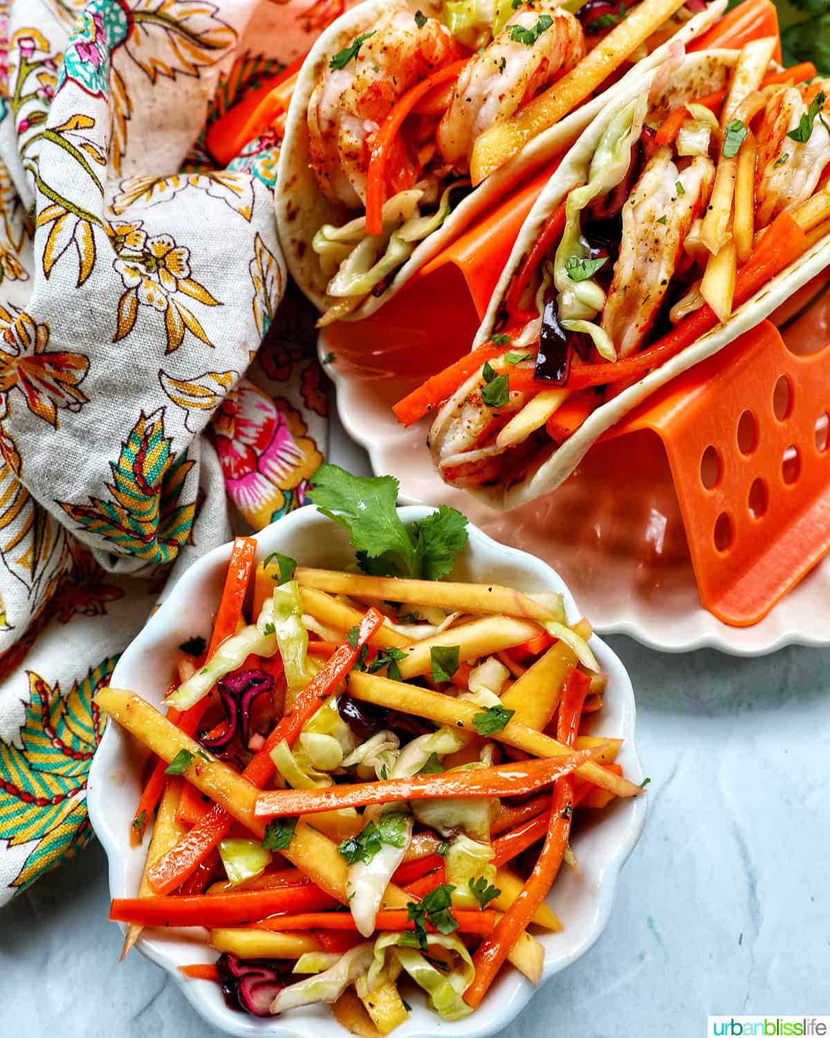 shrimp tacos on a plate with a side of mango slaw.