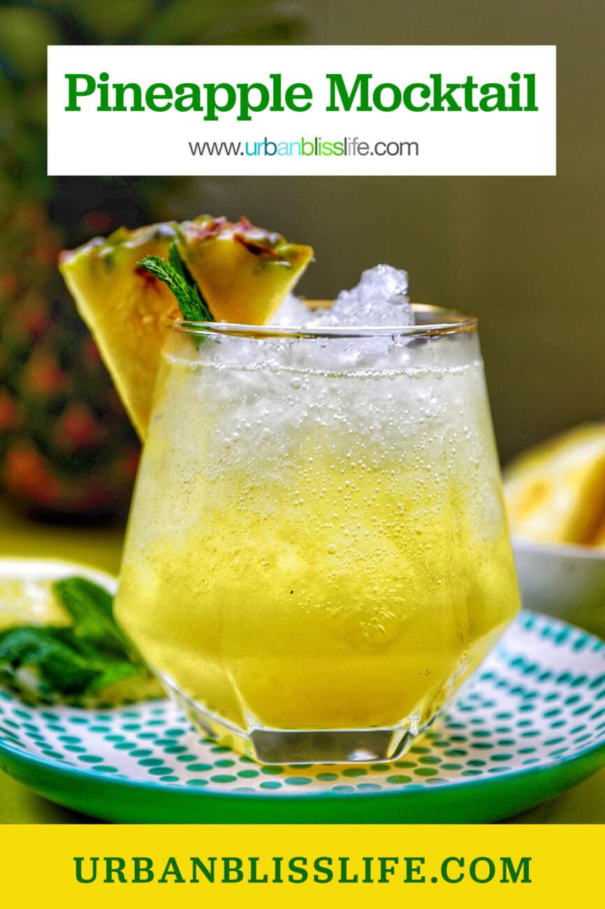 glass of pineapple mocktail with mint leaves and pineapple slice garnish.