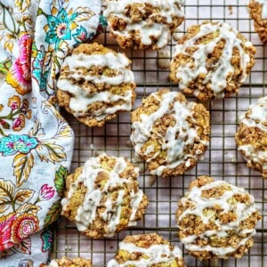 several vegan cinnamon streusel muffins on a wire rack with a colorful floral napkin.