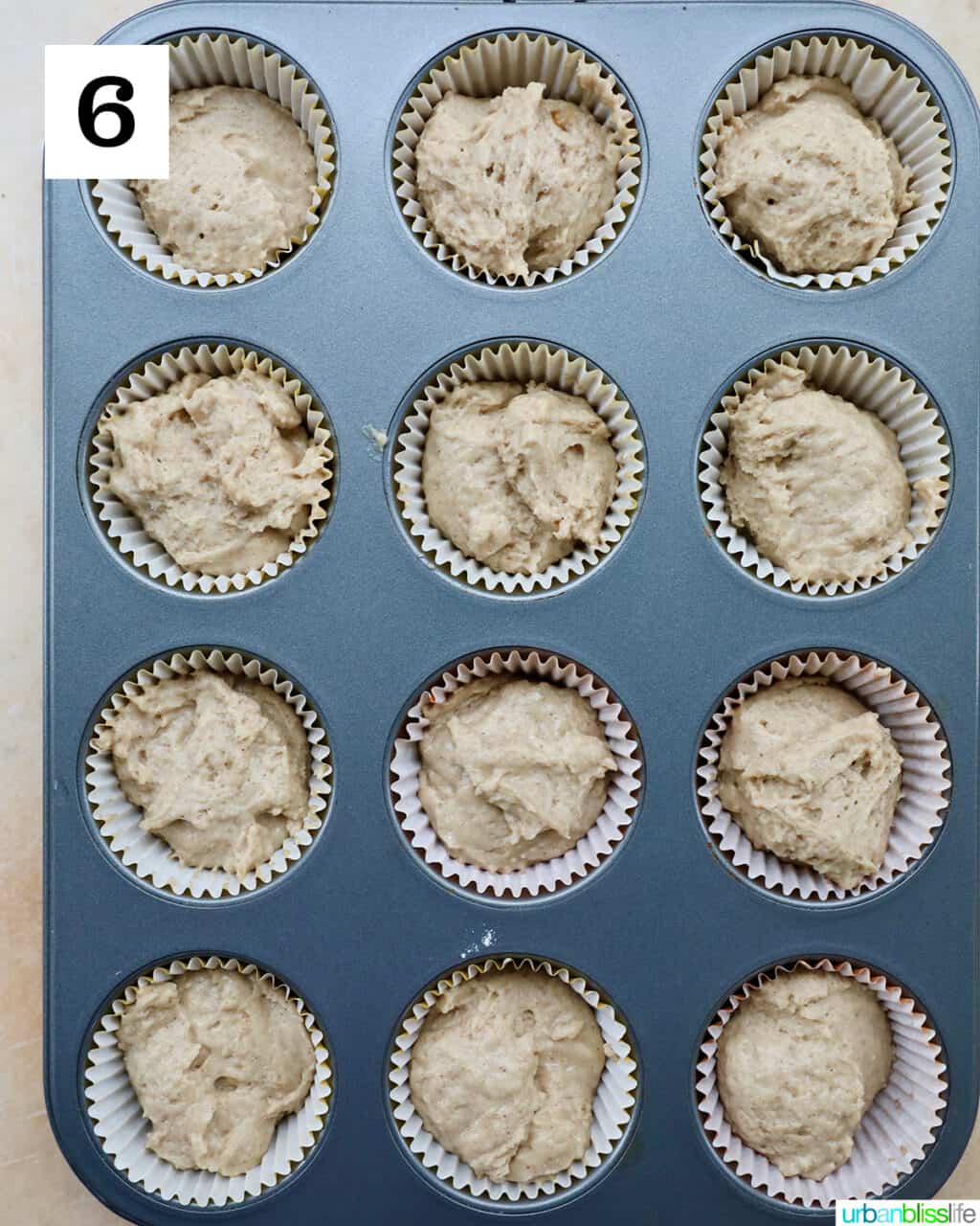 several vegan cinnamon streusel muffins in a muffin tin.