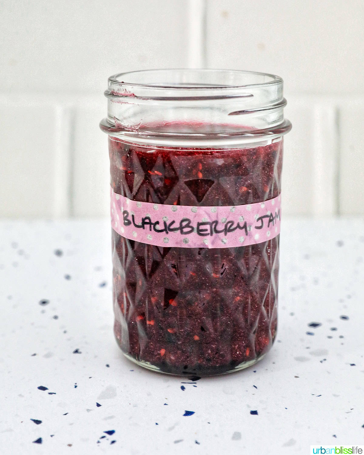 mason jar filled with blackberry freezer jam.