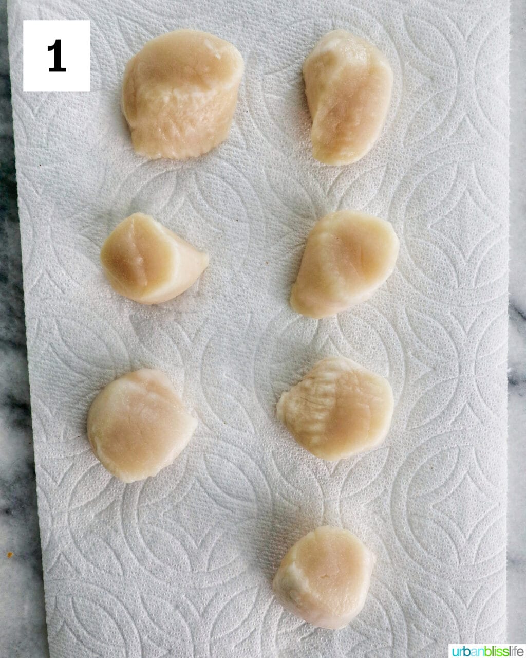 raw scallops on a paper towel.