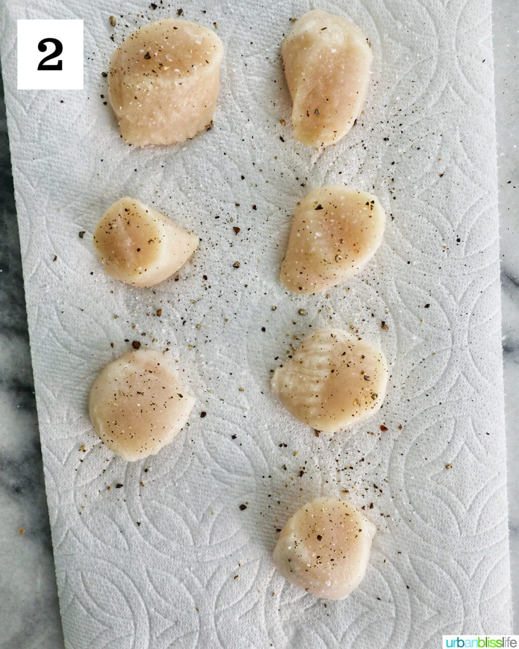 seasoned raw scallops on a paper towel.
