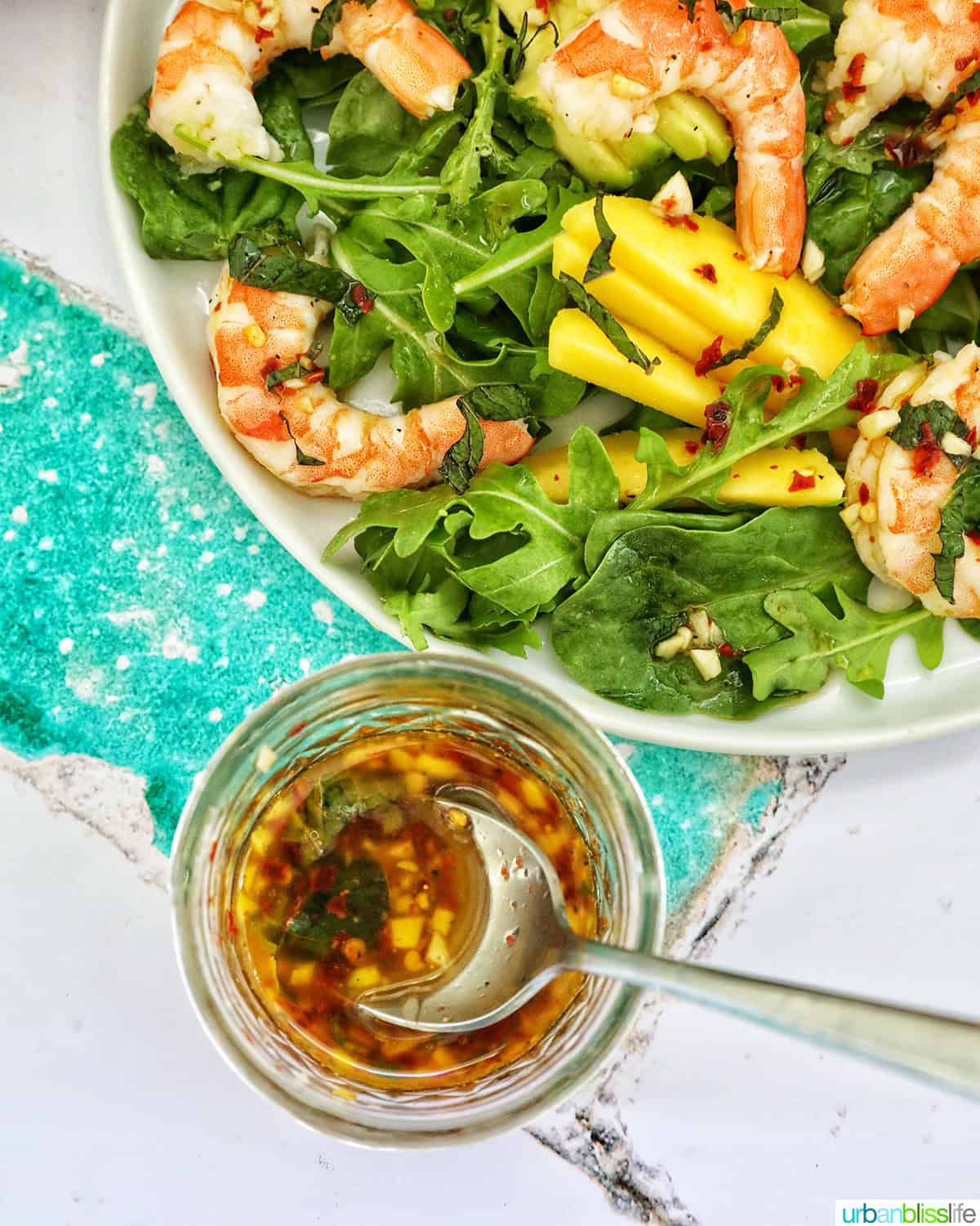 mango avocado prawn salad with jar of chili lime vinaigrette dressing.