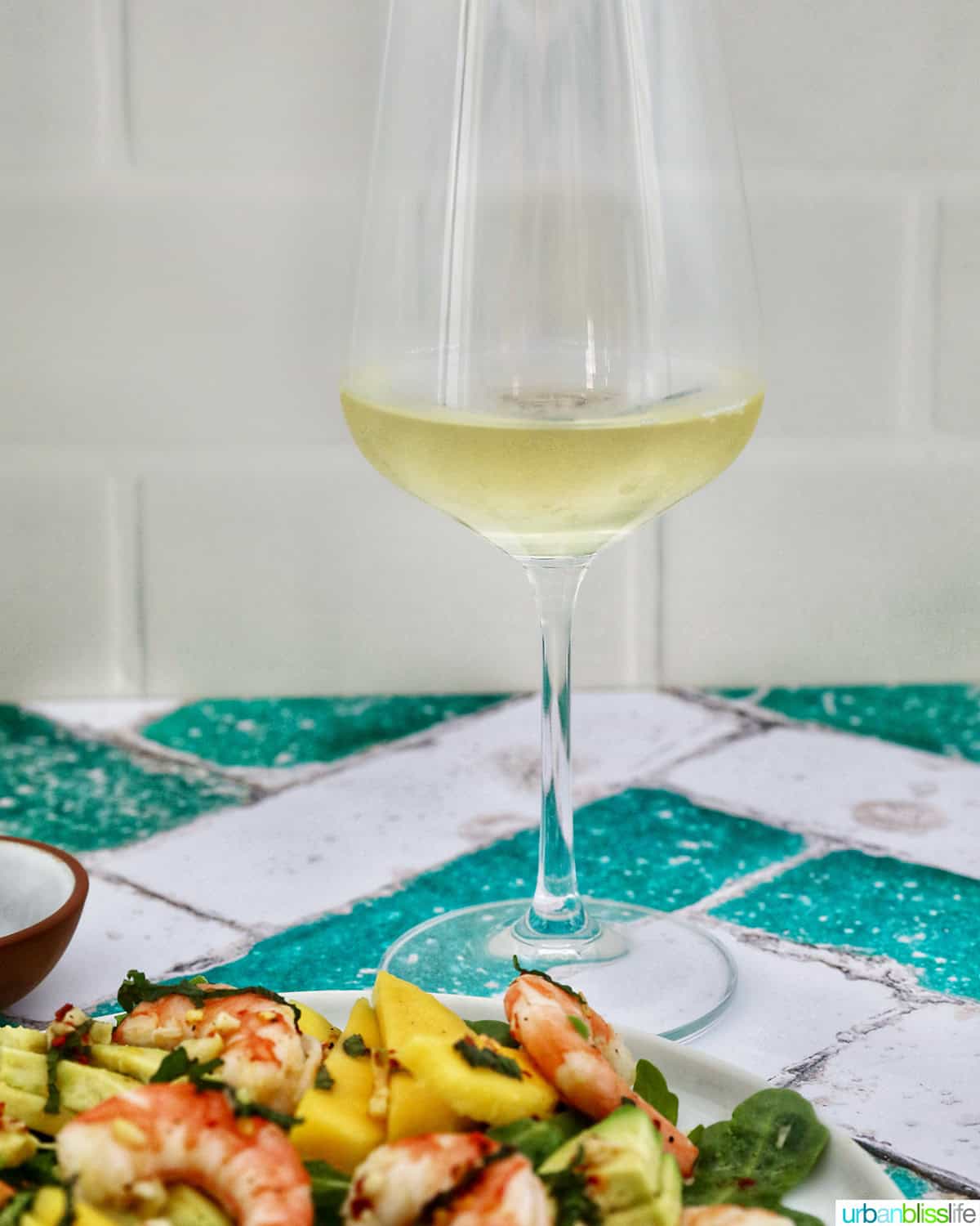 mango avocado prawn salad with glass of white wine.