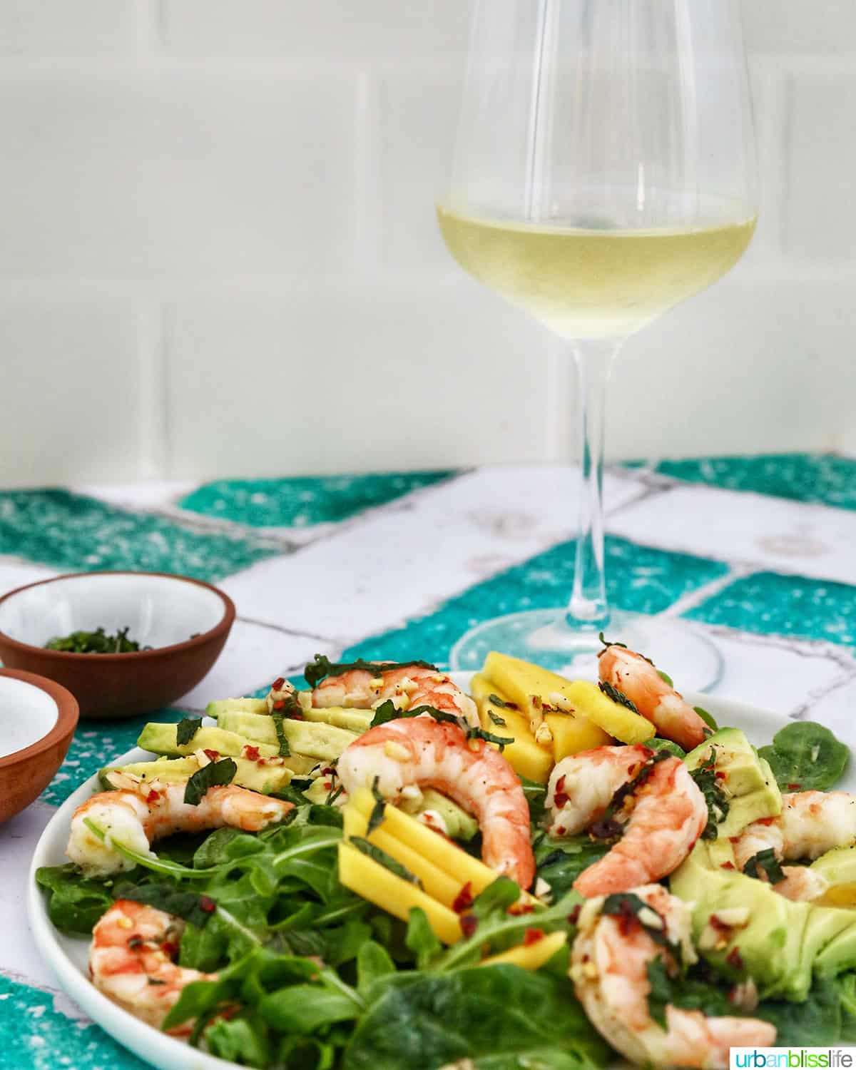 mango avocado prawn salad with glass of white wine.