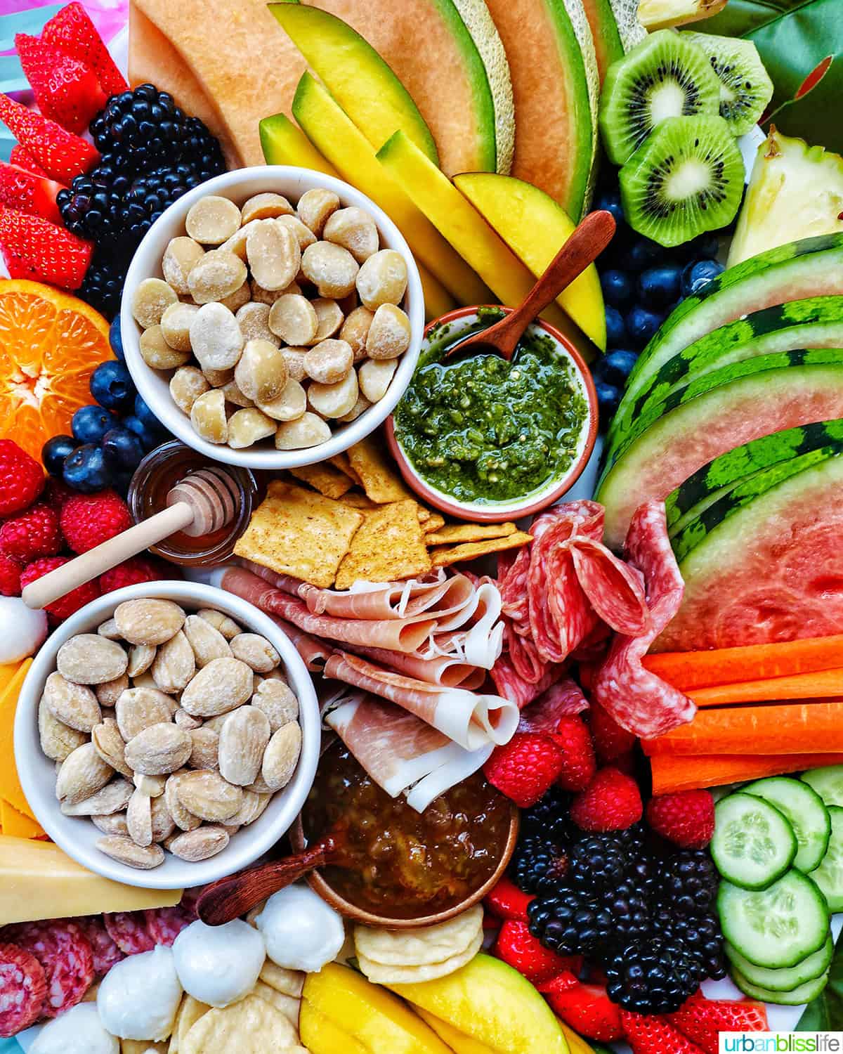 nuts, vegetables, meats, cheeses, fruits on a board.