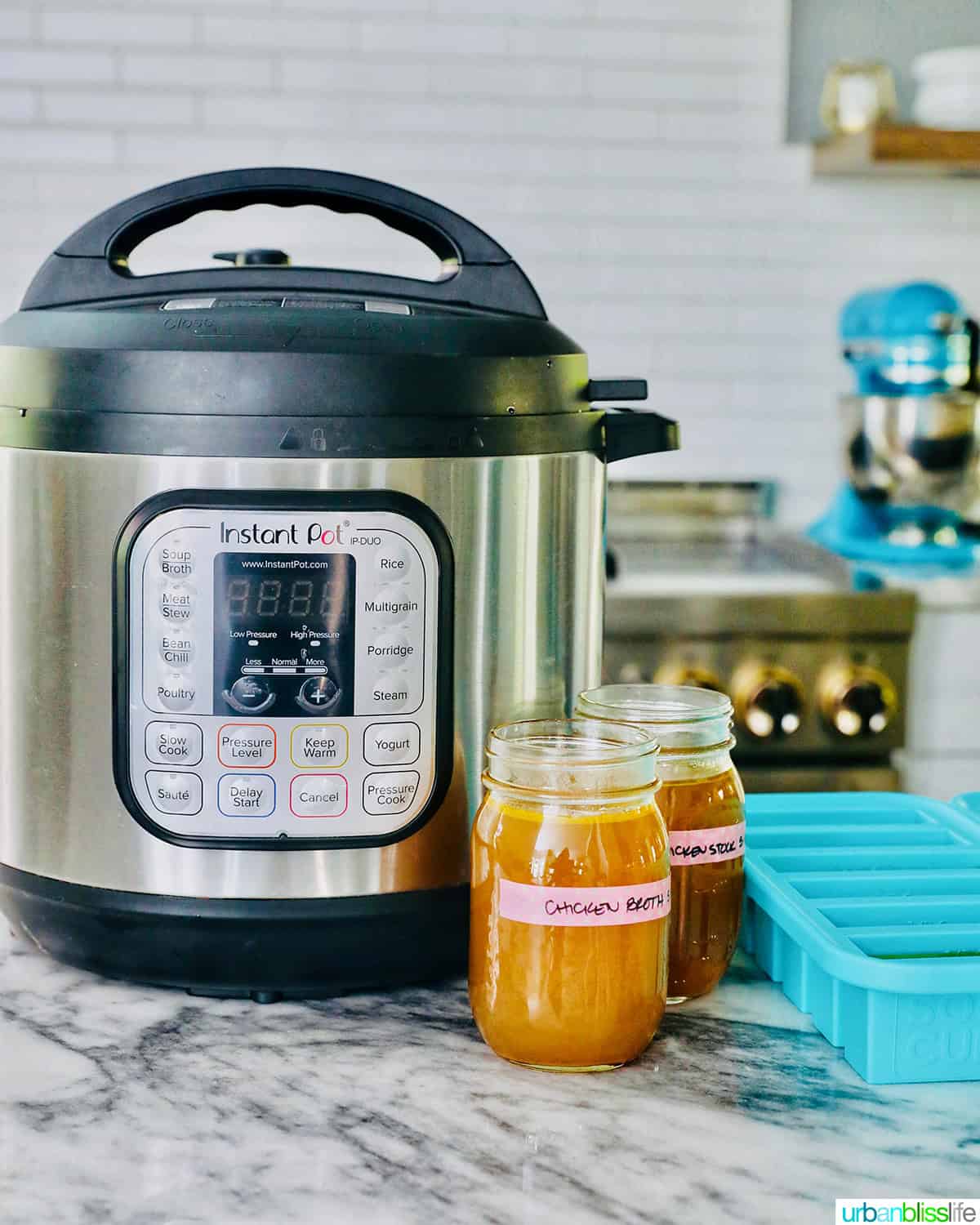 Instant Pot next to mason jars and food storage souper cubes filled with homemade chicken stock.