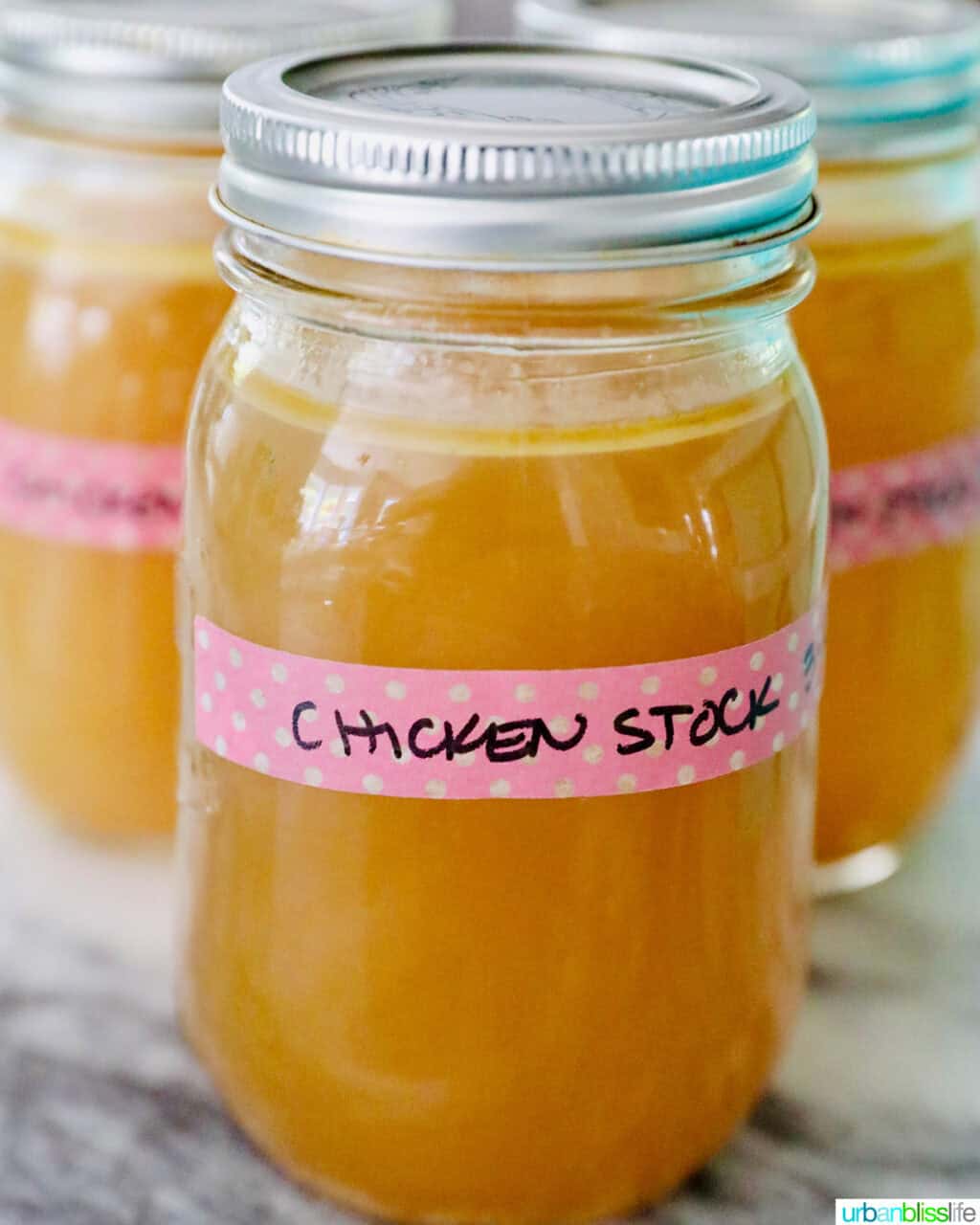 mason jar with liquid in it labeled "chicken stock."