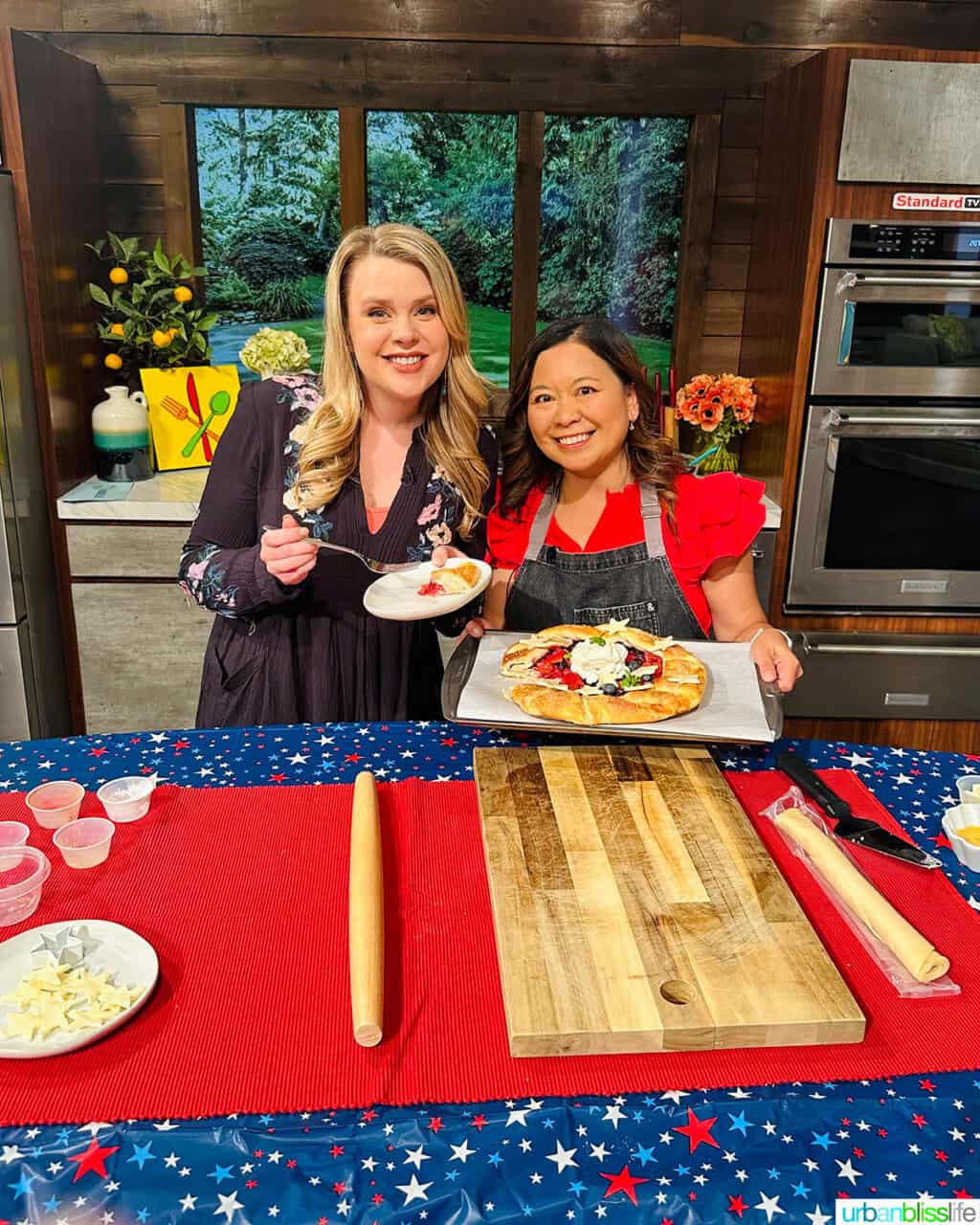 AfternoonLive Host Hannah Olsen and chef Marlynn Jayme Schotland holding mixed berry galettes on set.