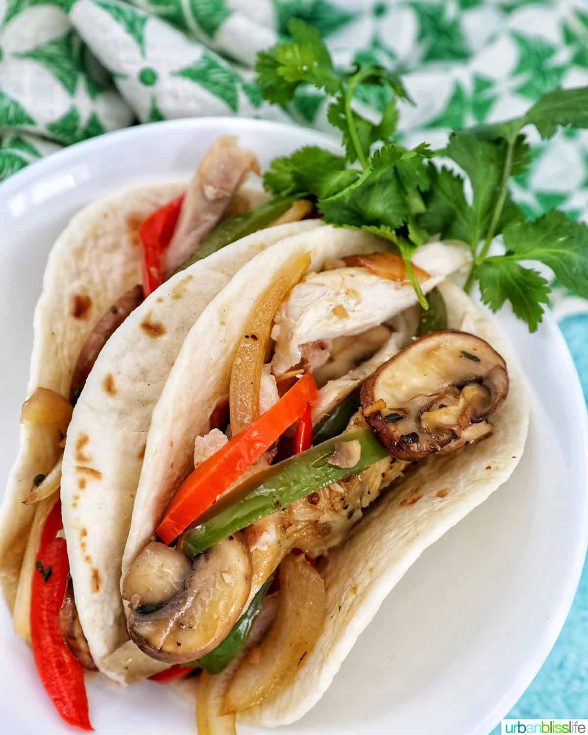 sautéed peppers and onions with chicken tacos and garnish of parsley.