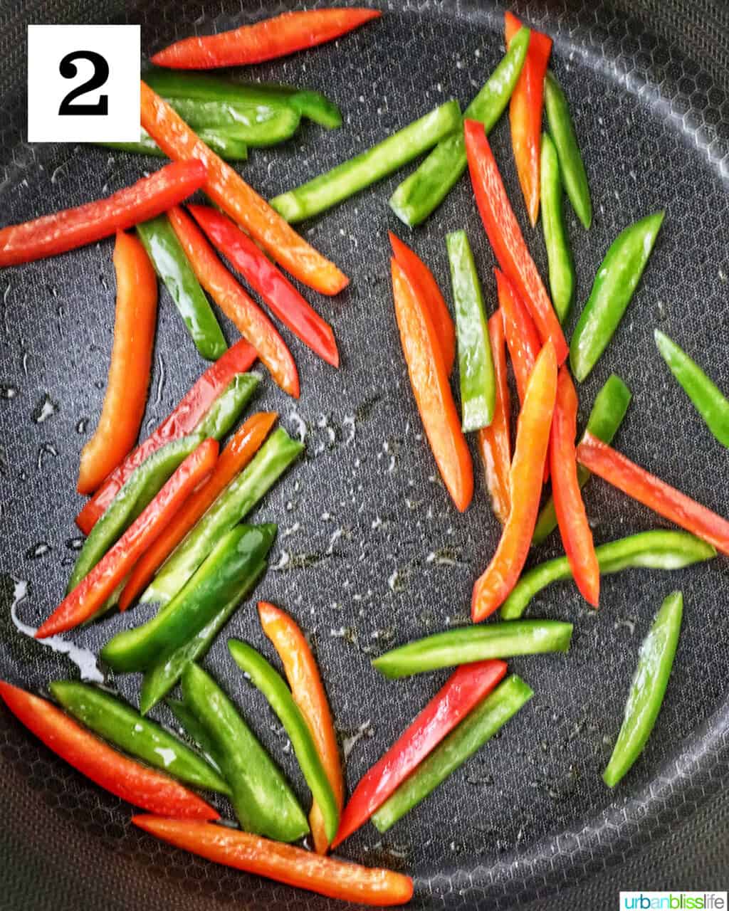 sautéed peppers and onions cooking in a skillet.