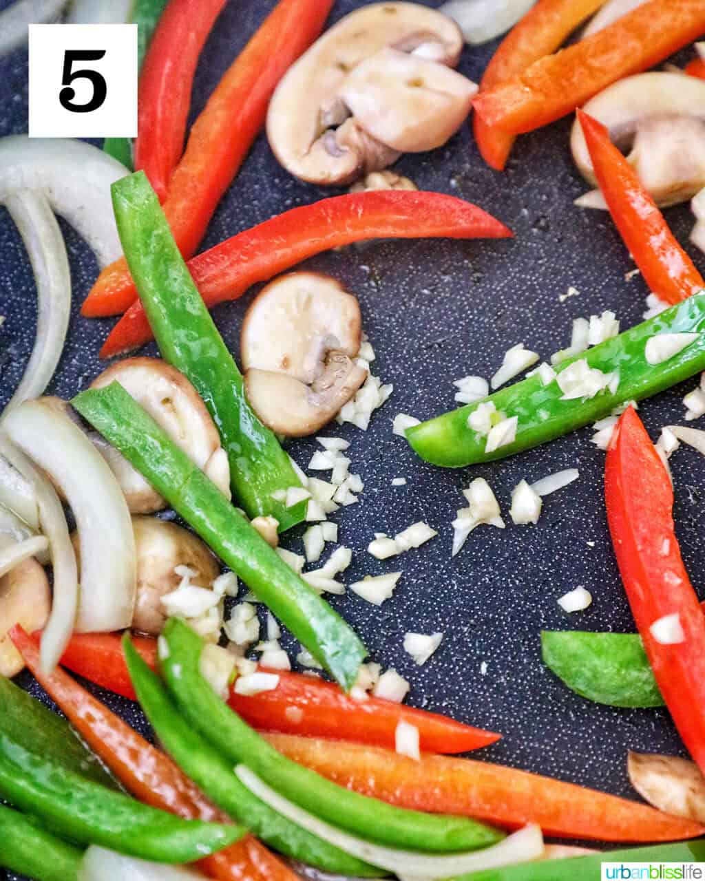 sautéed peppers and onions cooking in a skillet.