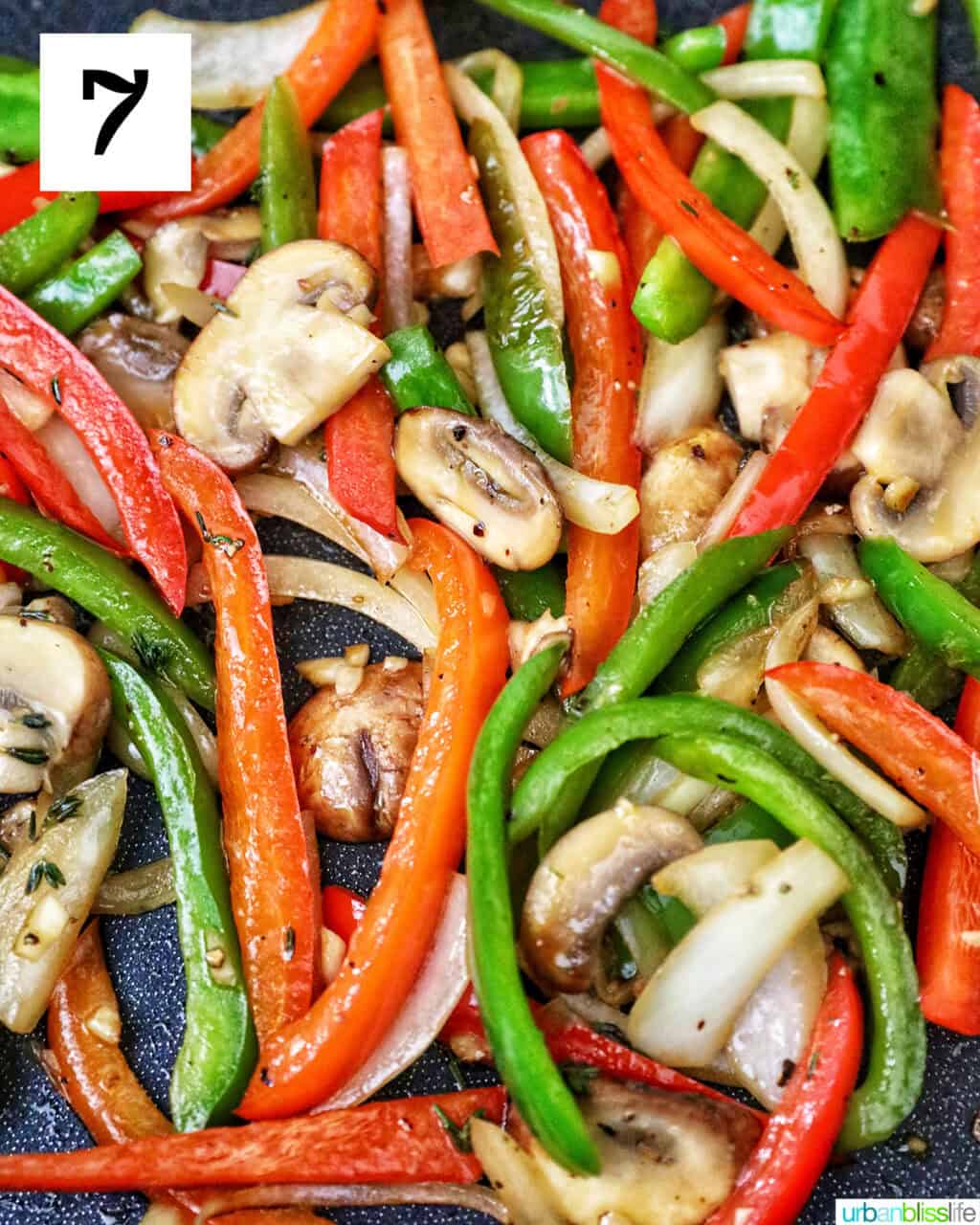 sautéed peppers and onions cooking in a skillet.