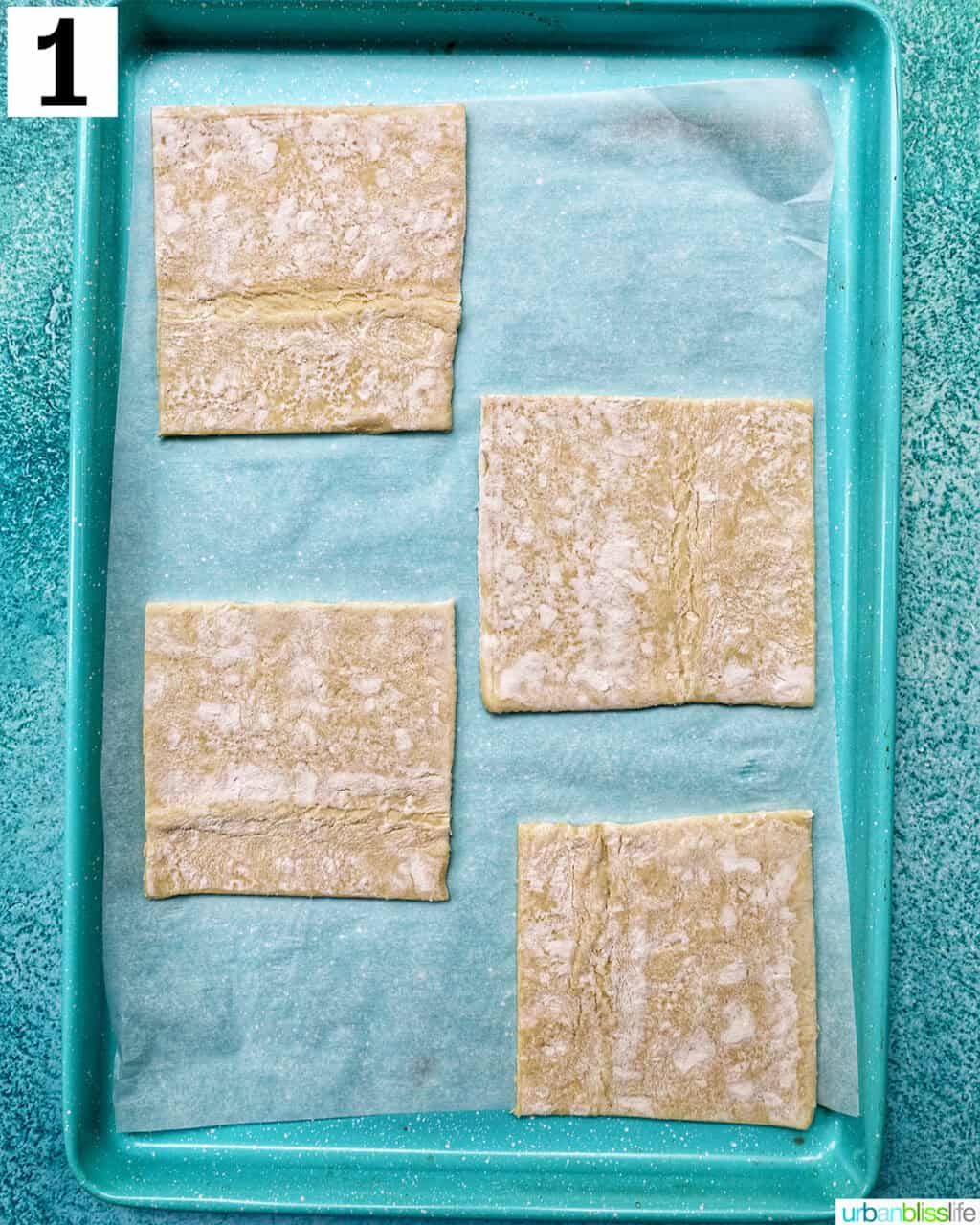 puff pastry squares on a parchment paper-lined baking sheet.