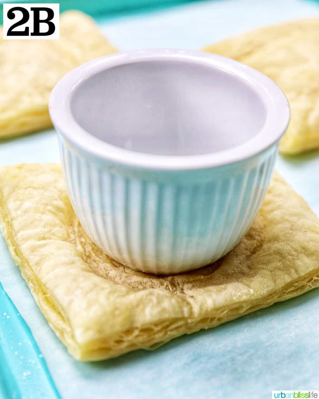 white ramekin on top of a square of puff pastry.