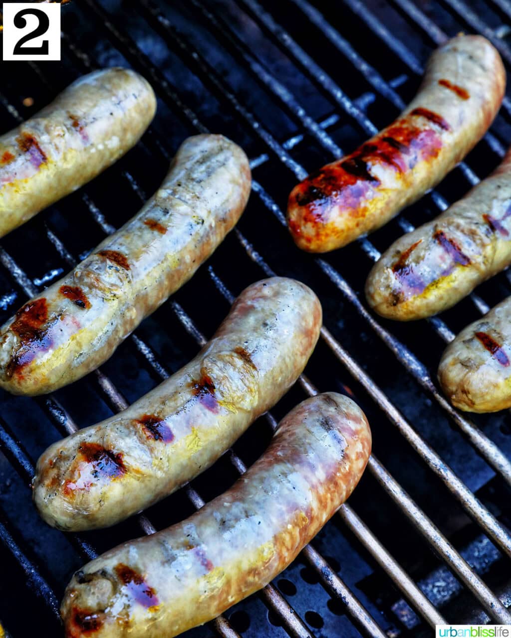 brats cooking on a grill