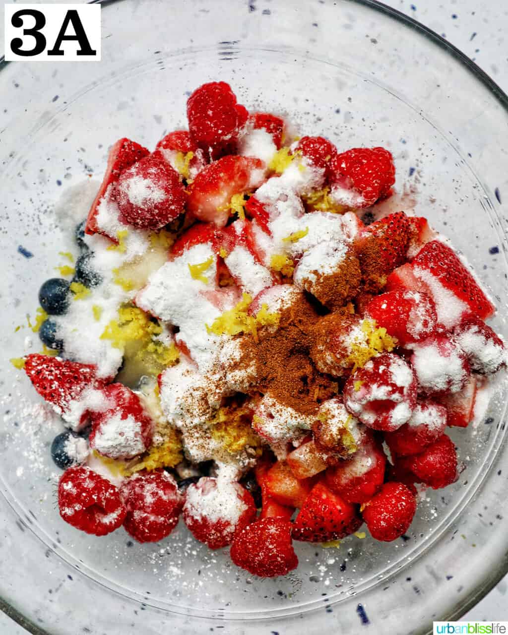 mixed berries in a bowl with cornstarh, lemon zest, lemon juice, cinnamon.