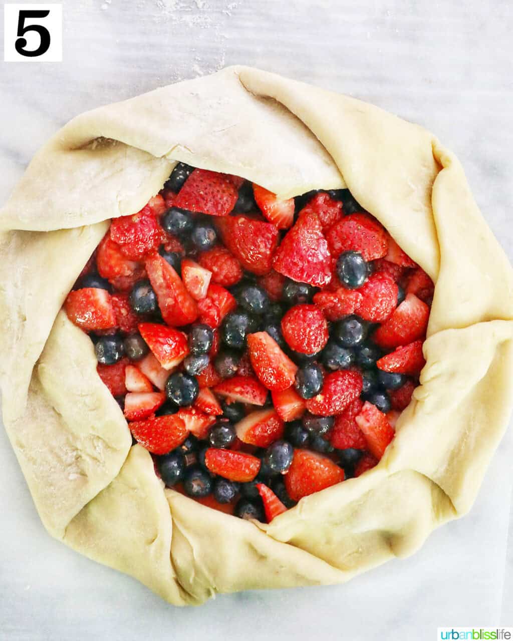 mixed berries in the center of pie dough on parchment paper.