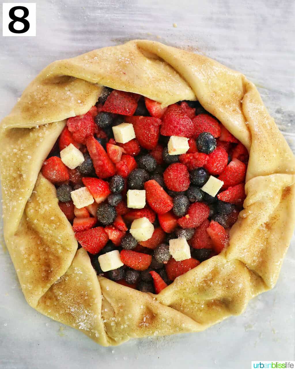 mixed berries in the center of pie dough on parchment paper.