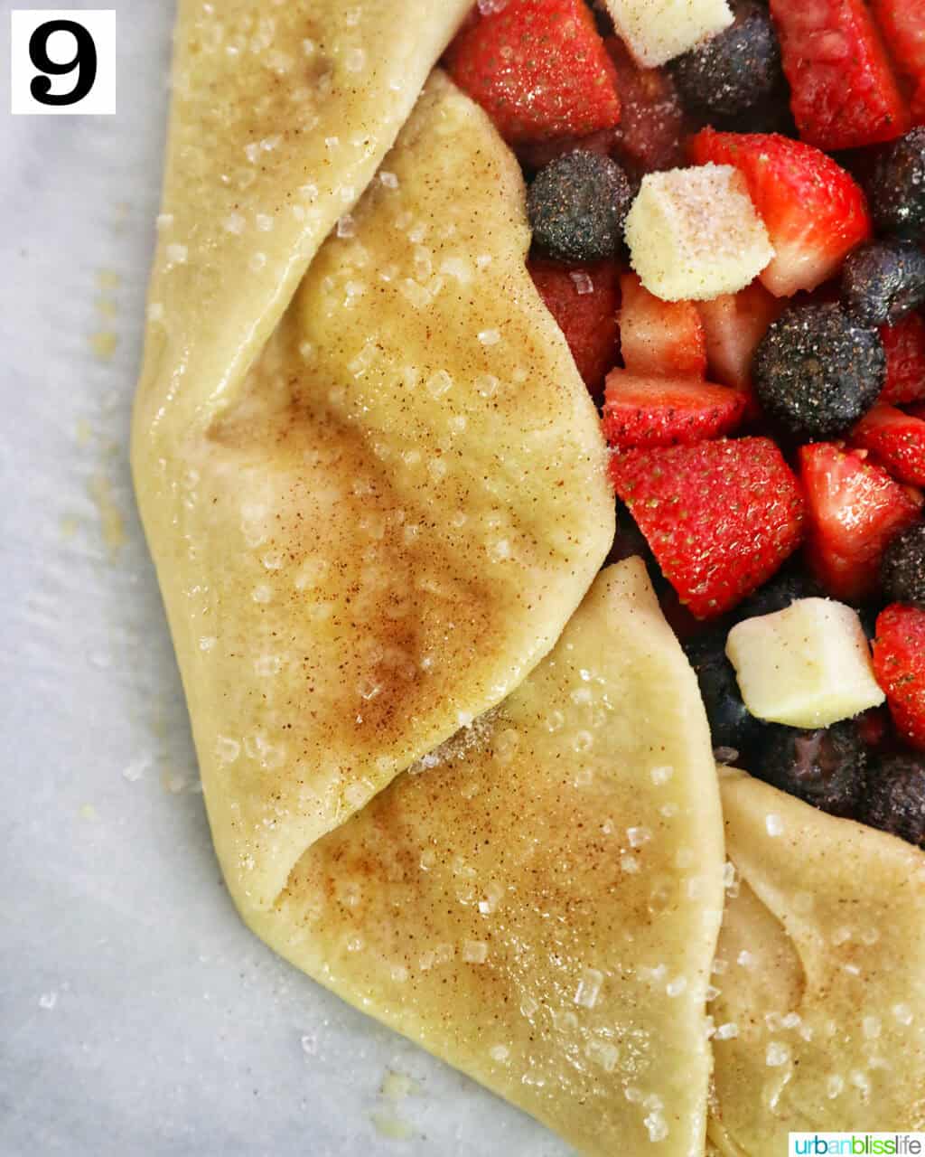 mixed berries in the center of pie dough on parchment paper.