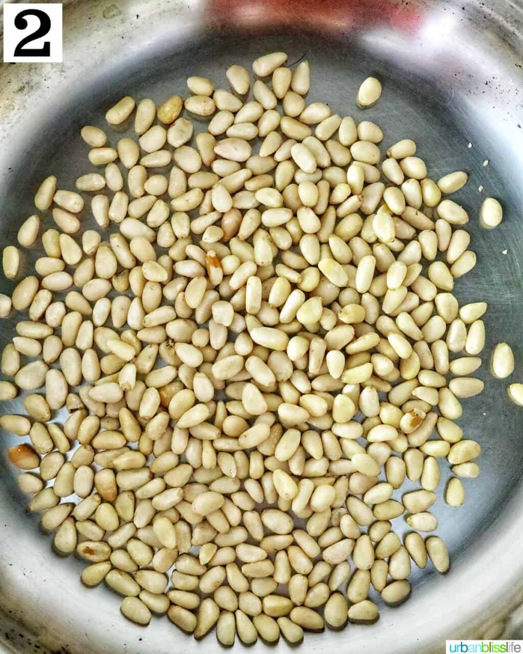 pine nuts toasting in a pan.