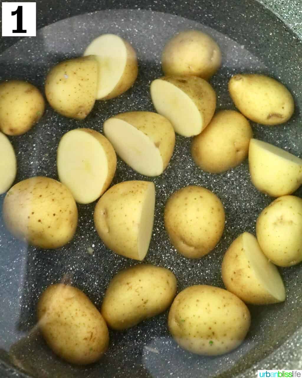 halved baby gold potatoes in water in a large pot.
